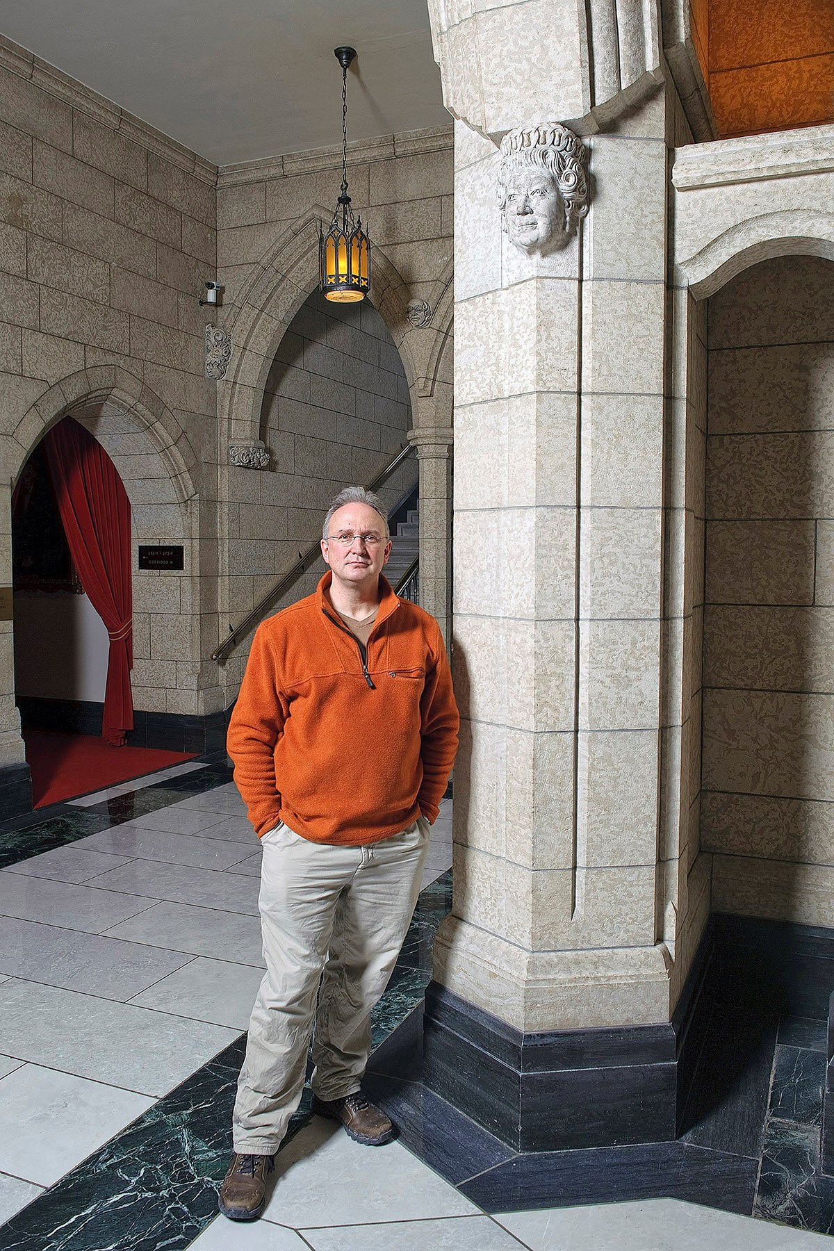 Dominion Sculptor Phil White stands beside the corbel portrait of Queen Elizabeth II he carved in 2010. (Photo credit: Public Services and Procurement Canada)