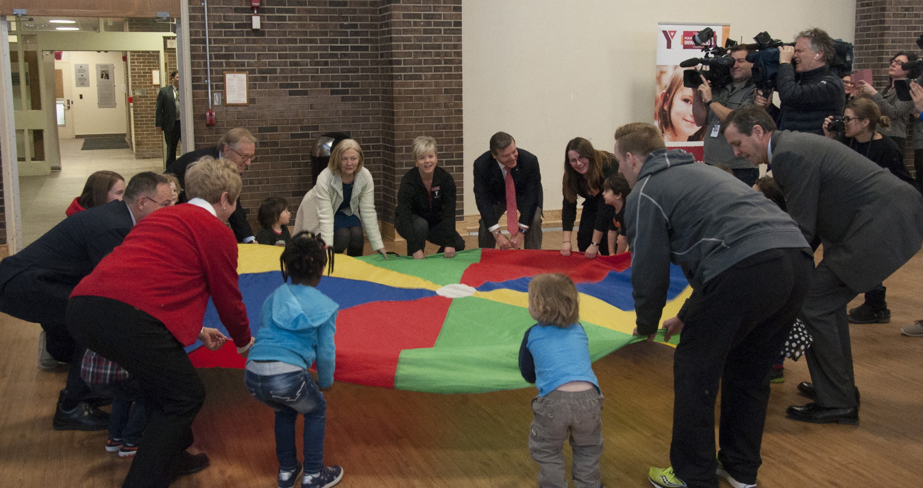 Members of the Senate Committee on Social Affairs, Science and Technology do parachute exercises with kids at an Ottawa YMCA ahead of the committee’s March 2016 press conference announcing the release of its report on obesity in Canada.