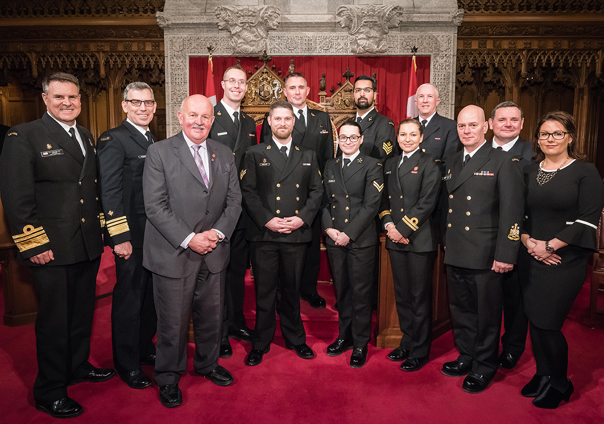 Senator Mercer stands with members of the Royal Canadian Navy and Canadian Coast Guard for Navy and Coast Guard Appreciation Day in the Senate in 2018.