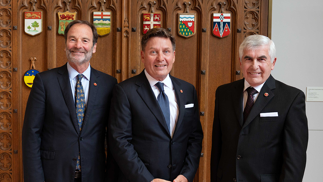 Trois sénateurs posent devant la Chambre rouge.