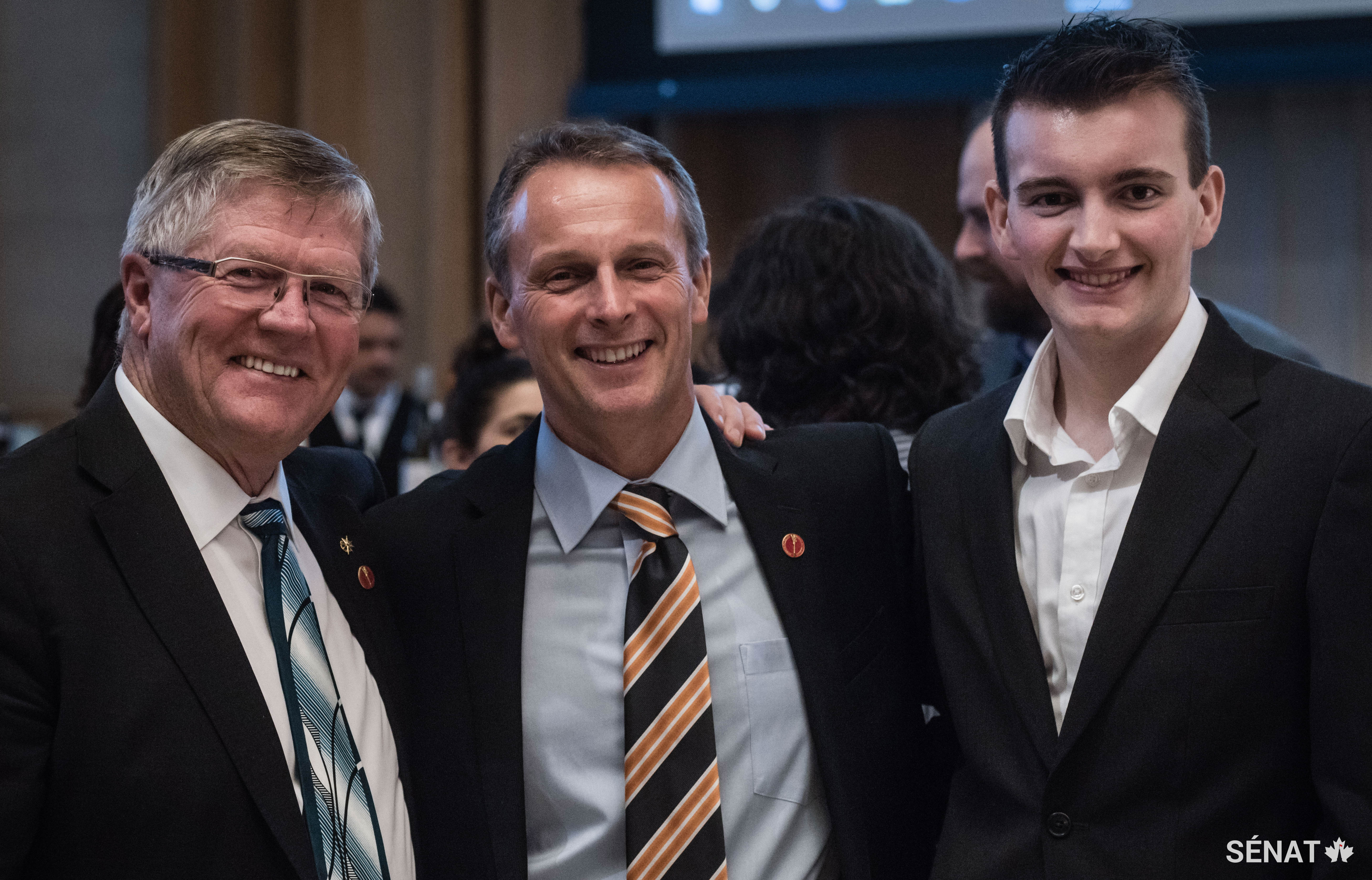 Les sénateurs Don Plett (à gauche) et David Wells (au centre) accompagné de son fils Luke, profitent de l’événement.