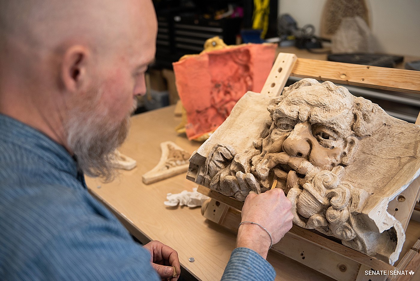 John-Philippe Smith, Team Lead at the Decorative Arts Studio, refines a clay model of a character — affectionately dubbed “Pipe Man” — located on a spire on the northwest corner of Centre Block.