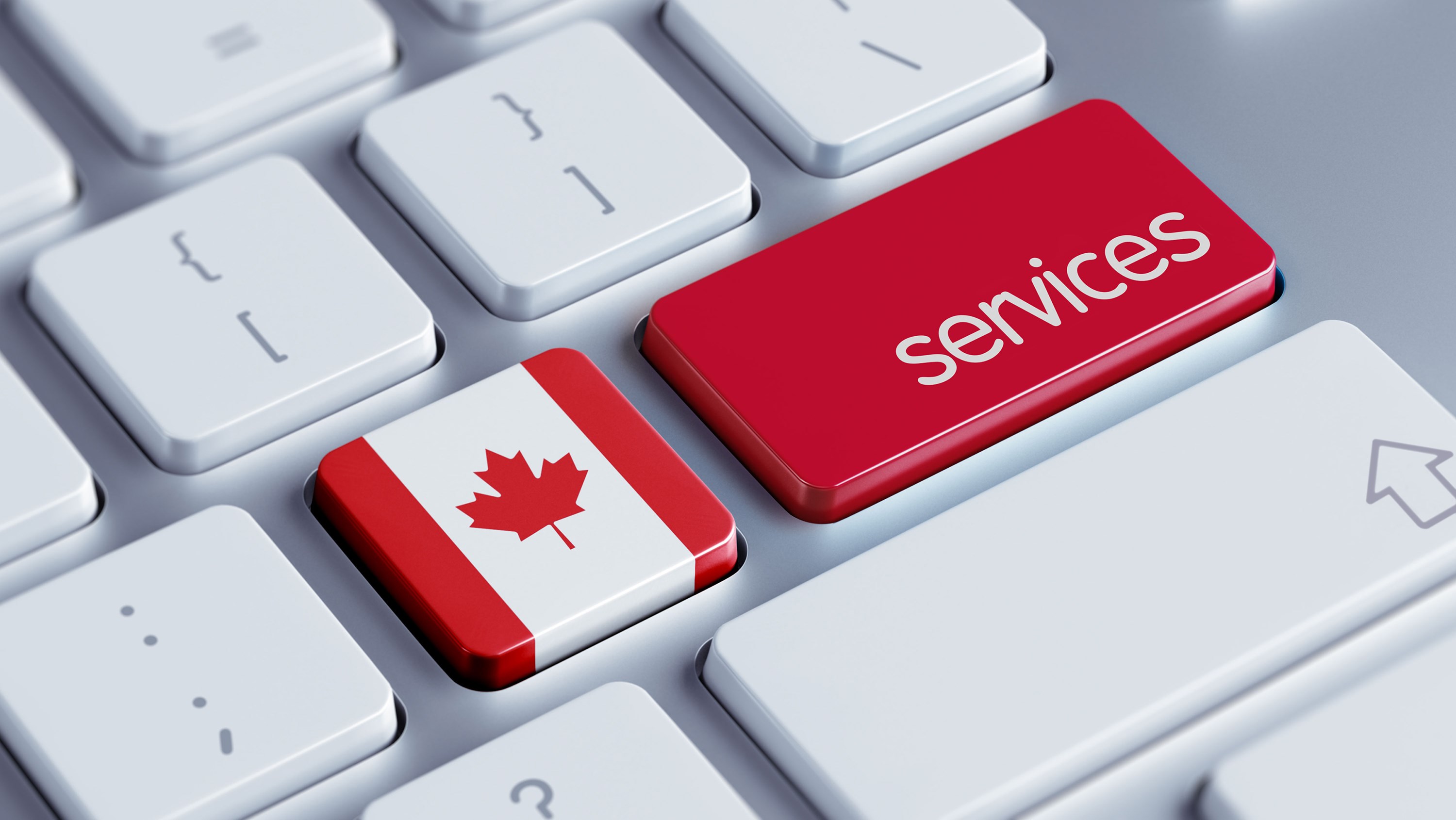 A white and silver keyboard containing two special keys: a square one with the Canada flag and a rectangular, red one with the word “services.”