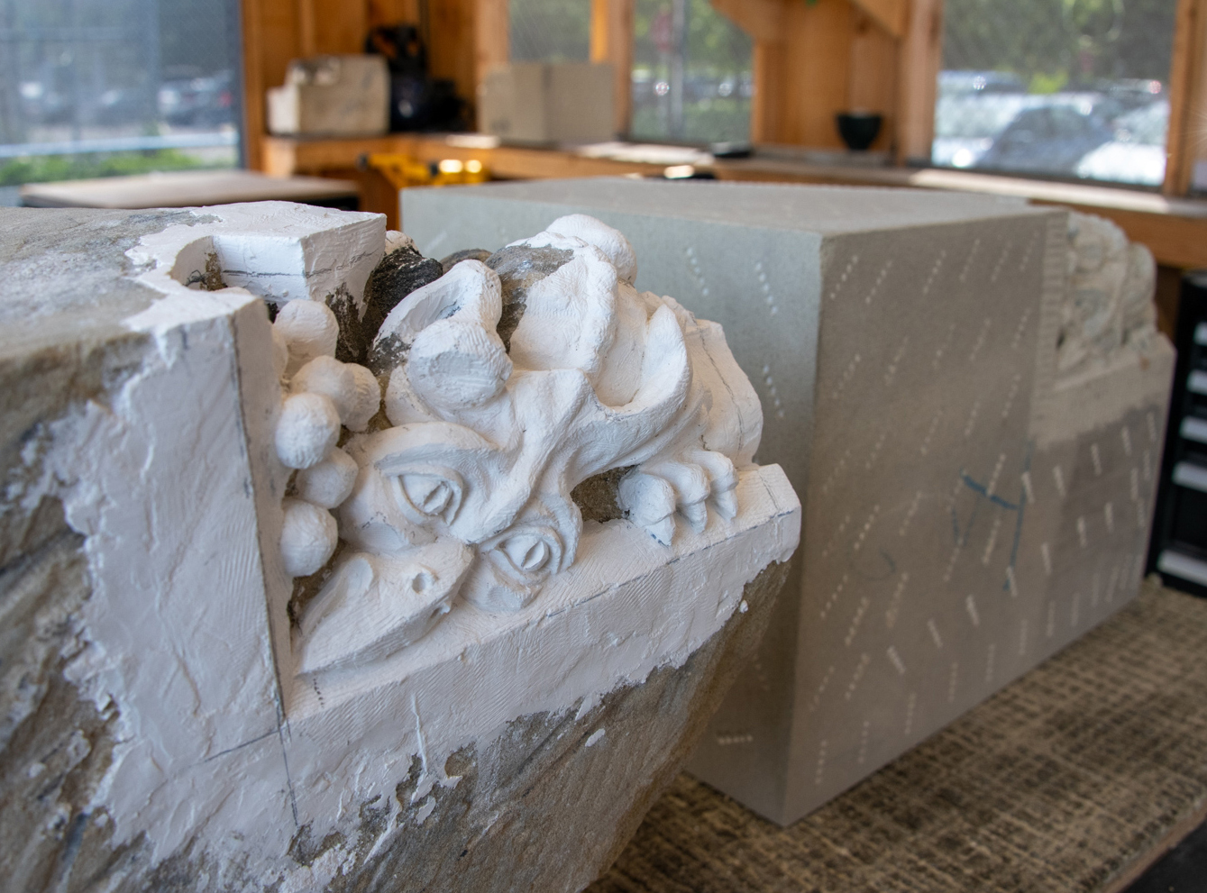 A carving of a bird-beaked dragon takes shape in Parliament’s Decorative Arts Studio. The version in the foreground is sculpted in plaster applied directly on top of the weathered stone original. It serves as a carving guide for the nearly complete replacement in the background.