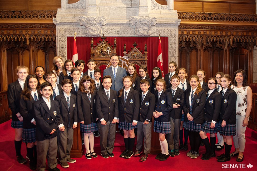 Students from the Socrates-Demosthenes school join Senator Housakos for a group photo in the Red Chamber.