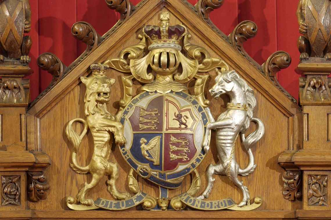 Le trône du monarque porte les armoiries du Royaume-Uni.