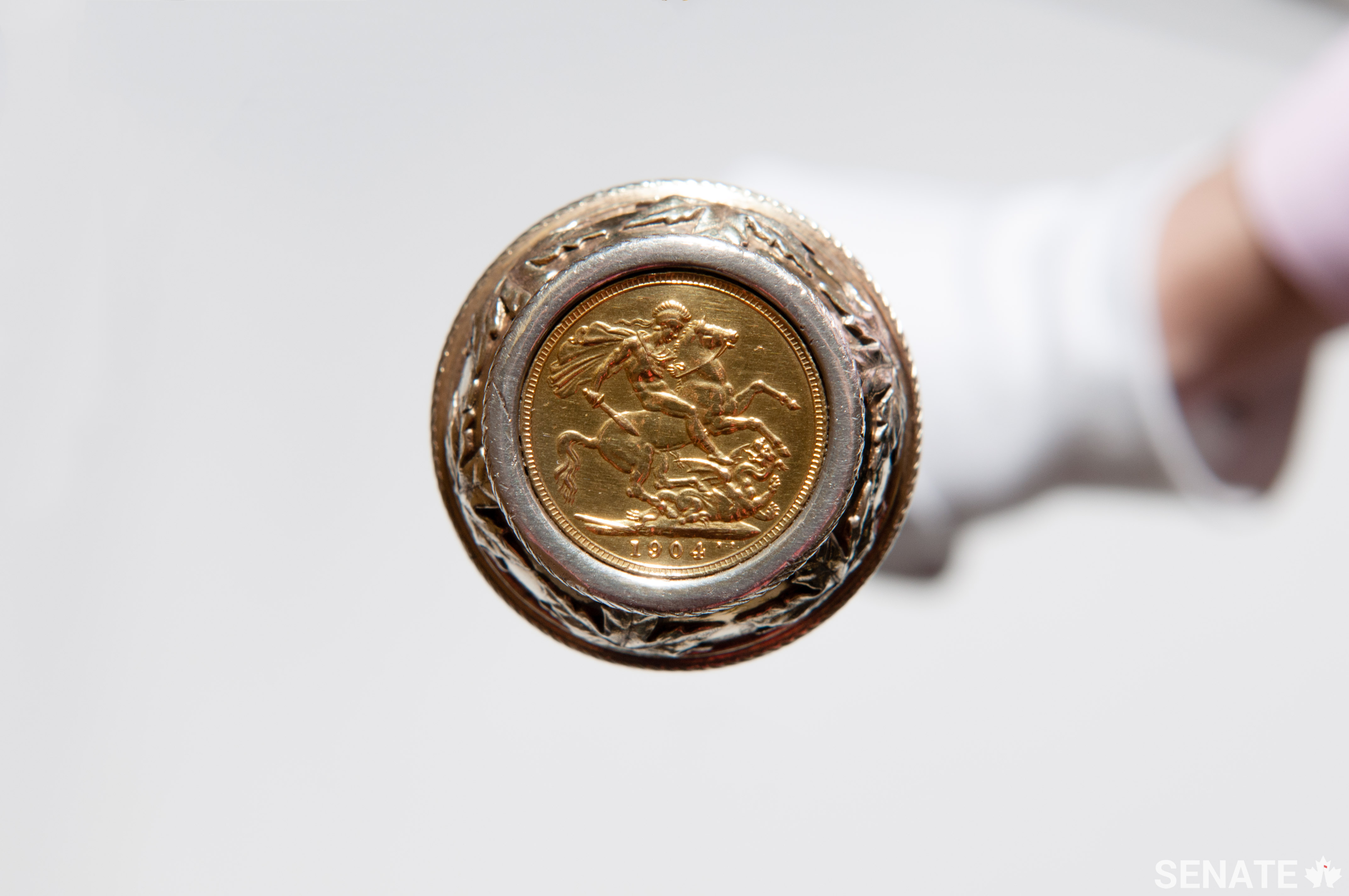 Set into the base of the Black Rod is a 1904 gold sovereign displaying St. George slaying the dragon. The Black Rod used in the British House of Lords also carries a 1904 gold sovereign.