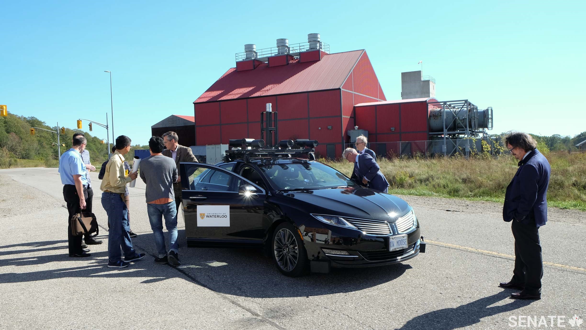 At the WatCar test track, Senators meet with engineering students before taking a spin in the <em>Autonomoose</em> on October 3, 2017.