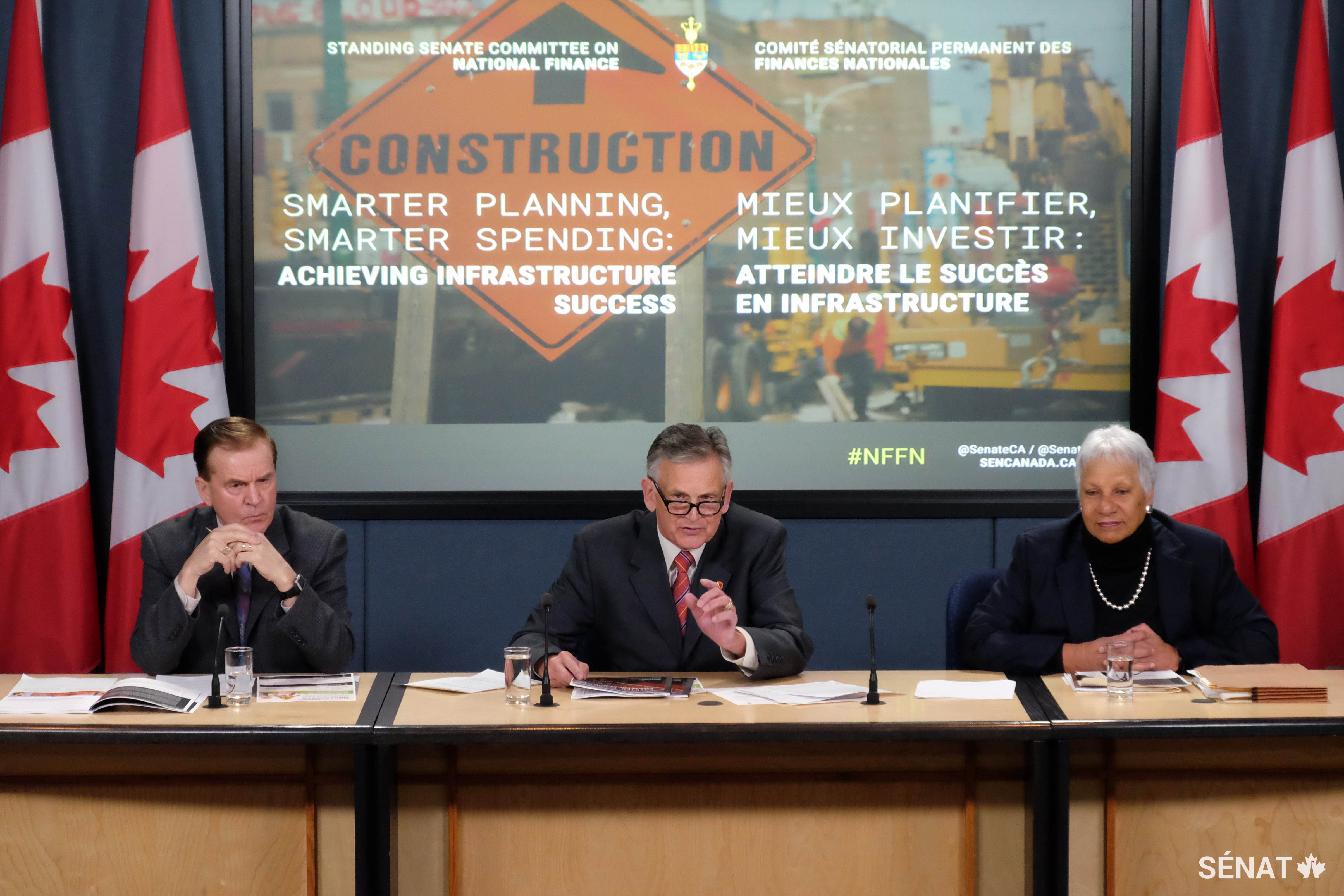 Le sénateur Smith, accompagné des sénateurs Percy Mockler et Anne C. Cools, répond aux questions des journalistes lors du dépôt du rapport du Comité sénatorial des finances nationales portant sur l’étude du programme d’infrastructure du gouvernement fédéral à Ottawa en février 2017.