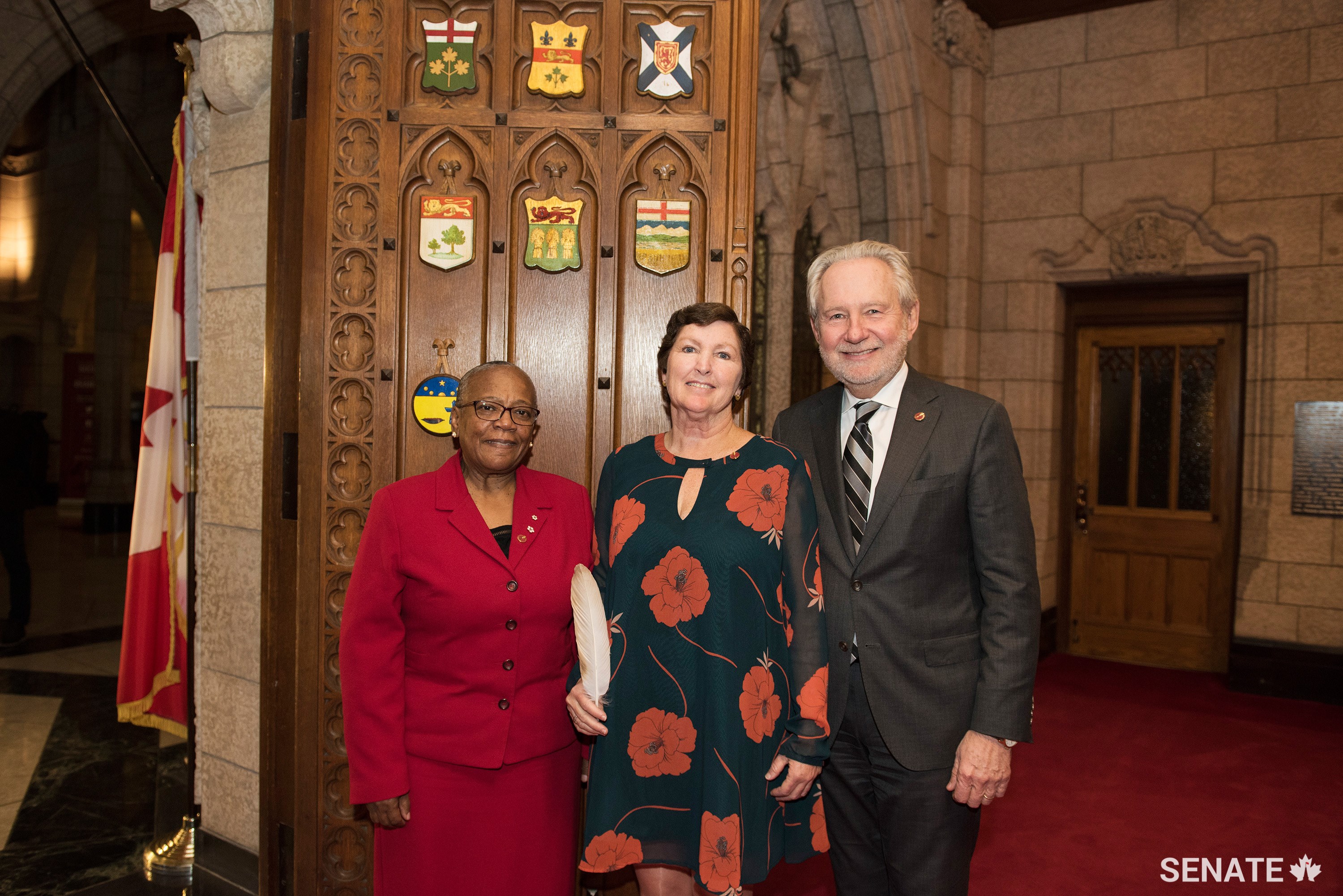 Senator Mary Coyle (centre) is welcomed to the Senate Chamber by Senator Peter Harder (right) and Senator Wanda Thomas Bernard (left)