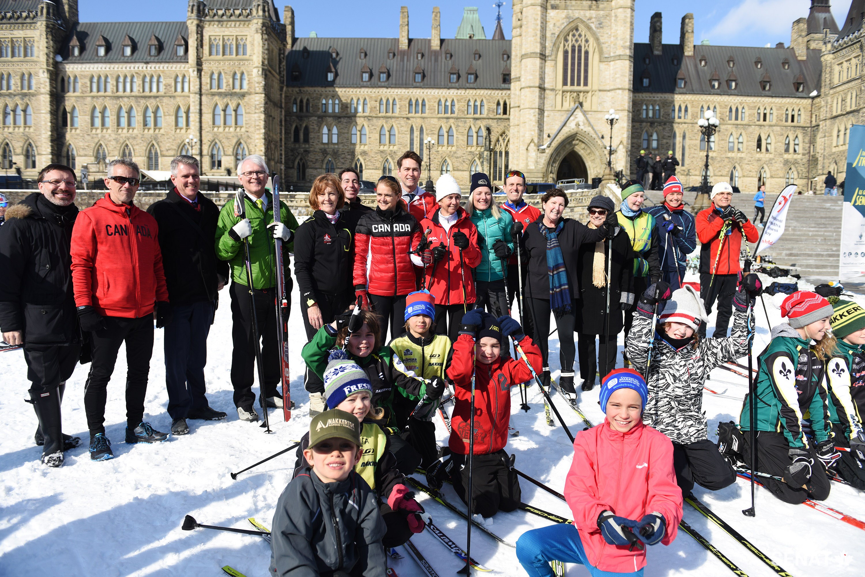 La gouverneure générale et des parlementaires en compagnie d'un groupe de jeunes skieurs enthousiastes prennent la pose. Quoi de plus plaisant qu'une journée de ski sur la Colline!
