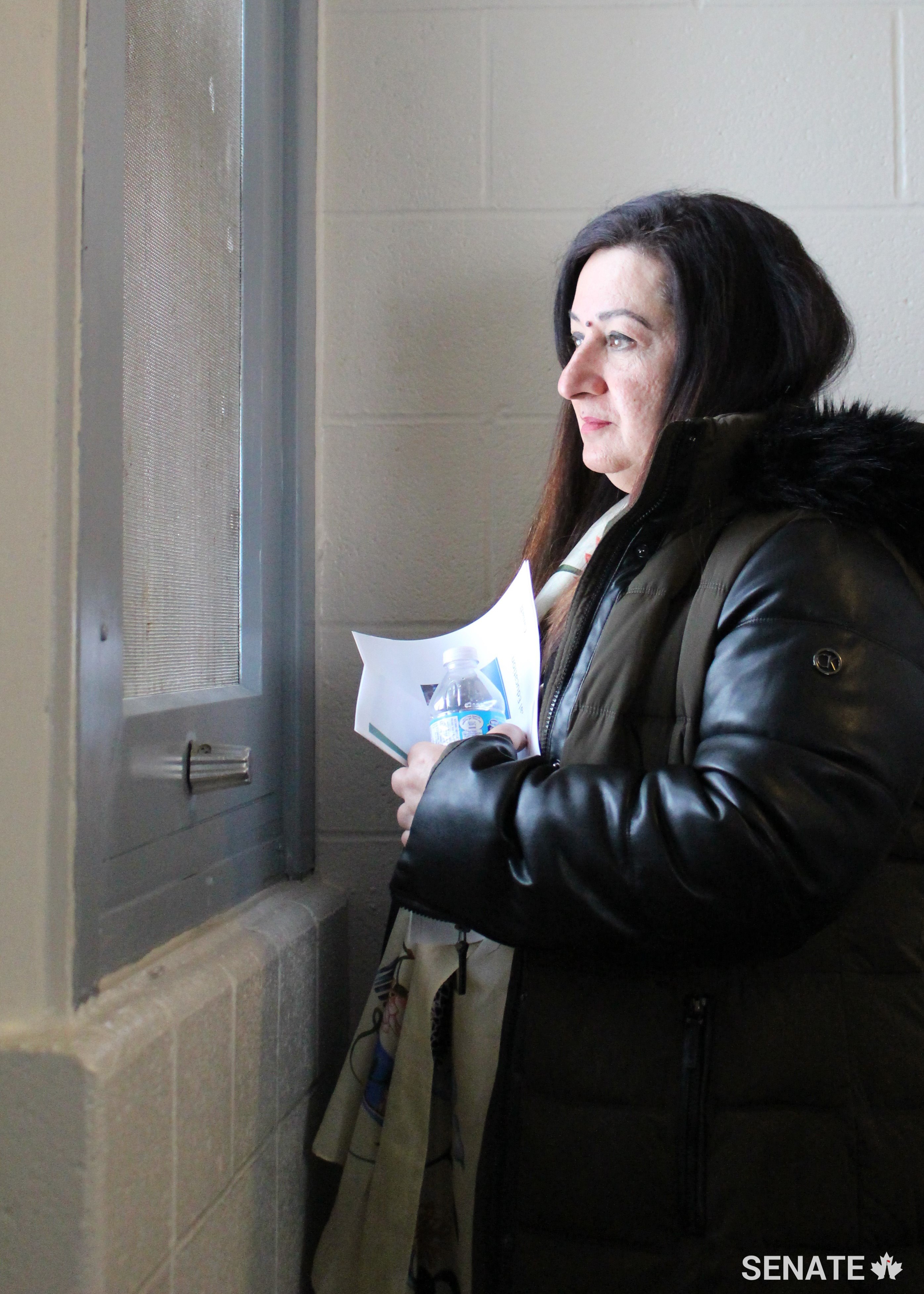 Senator Salma Ataullahjan, deputy chair of the committee, looks through the only window to the outside world in a segregation unit cell at the Grand Valley women's prison in Kitchener, Ont.