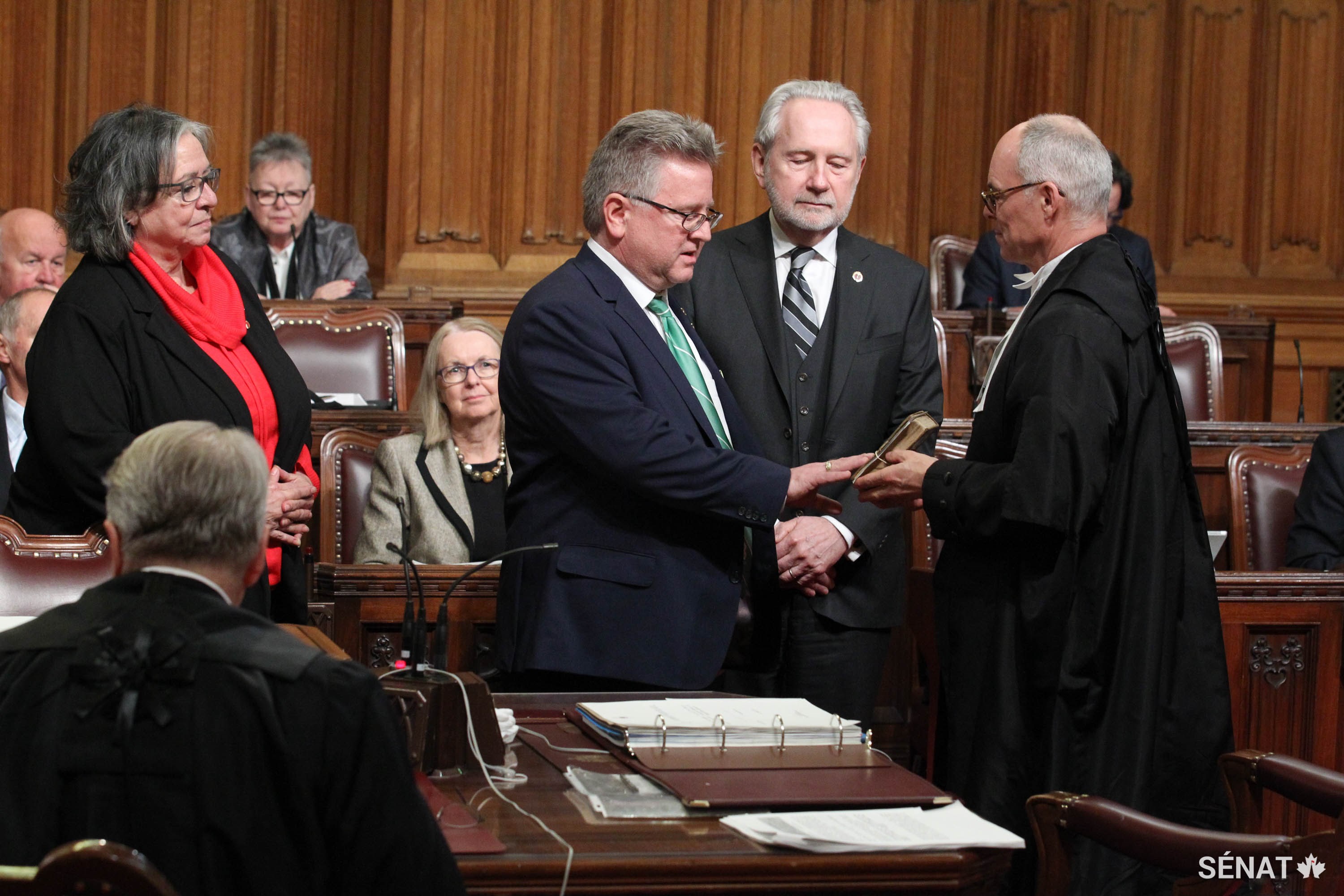 La sénatrice Julie Miville-Dechêne est accompagnée du sénateur Serge Joyal, à gauche, et du sénateur Peter Harder à la suite de sa cérémonie d'assermentation le 18 septembre 2018.
