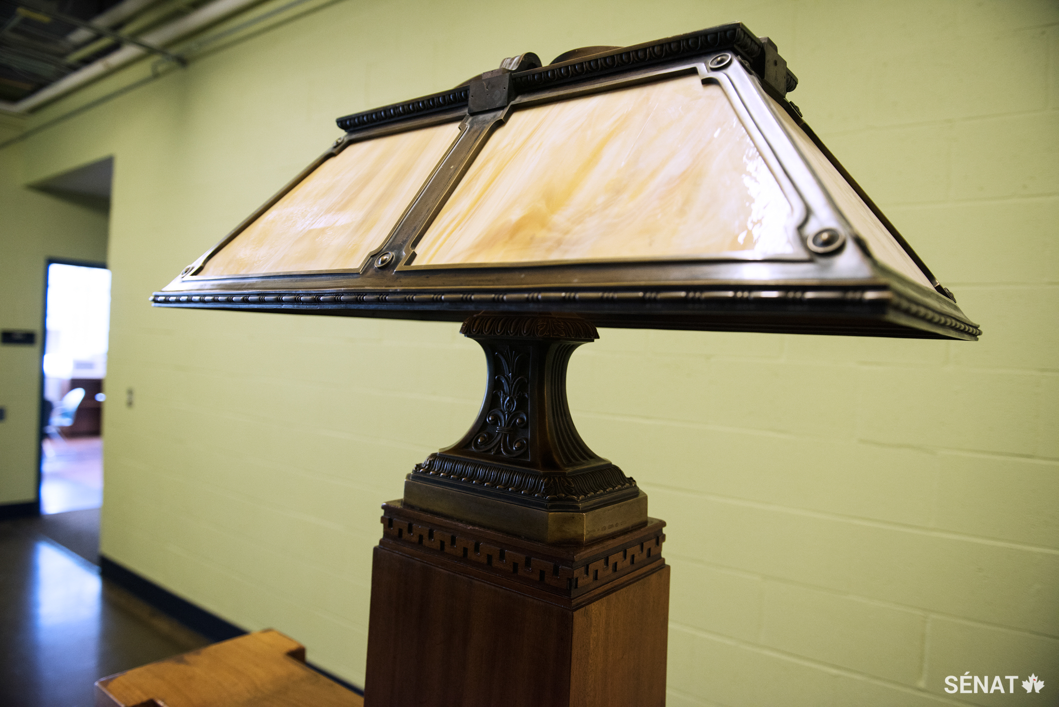 Deux lampes de style Tiffany munies d’un abat-jour en vitrail et de fixations en bronze surmontent le banc.