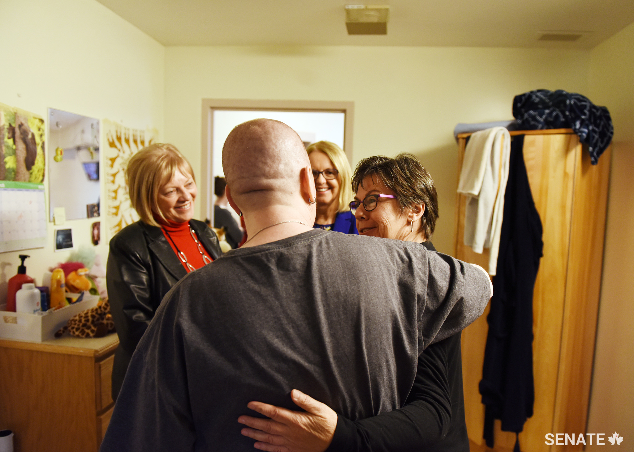 Senator Kim Pate shares a hug with a female hospital resident as Senator Nancy Hartling, left, and Senator Jane Cordy look on. The woman spent more than 20 years in custody — including ten years in solitary confinement — until she was diagnosed with schizophrenia and finally placed in the mental health system. For many people dealing with mental health issues, help only comes after they’ve entered the criminal justice system — if at all.
