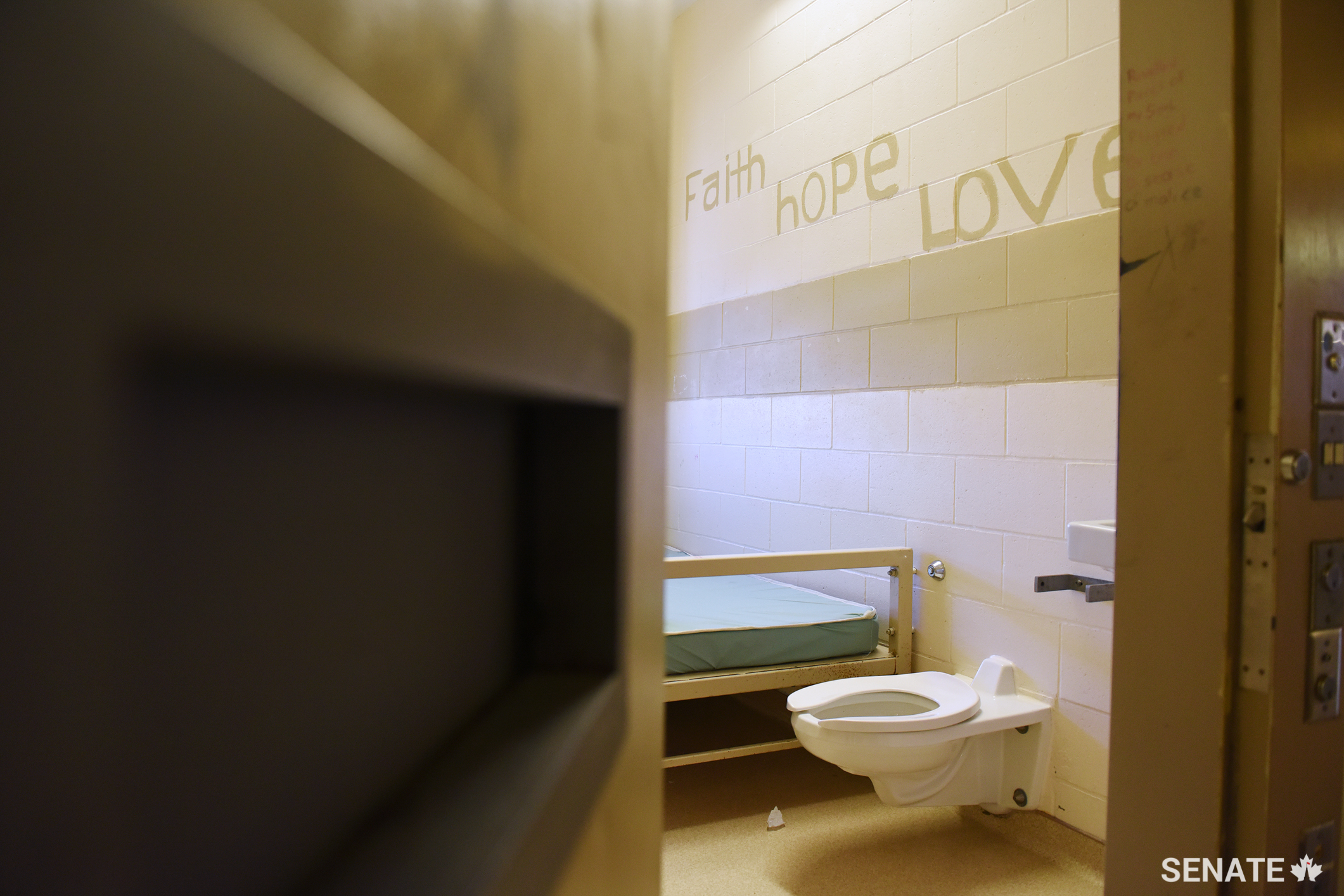 A prisoner’s hand-painted inspirational messages to herself are seen on the wall of her cell.