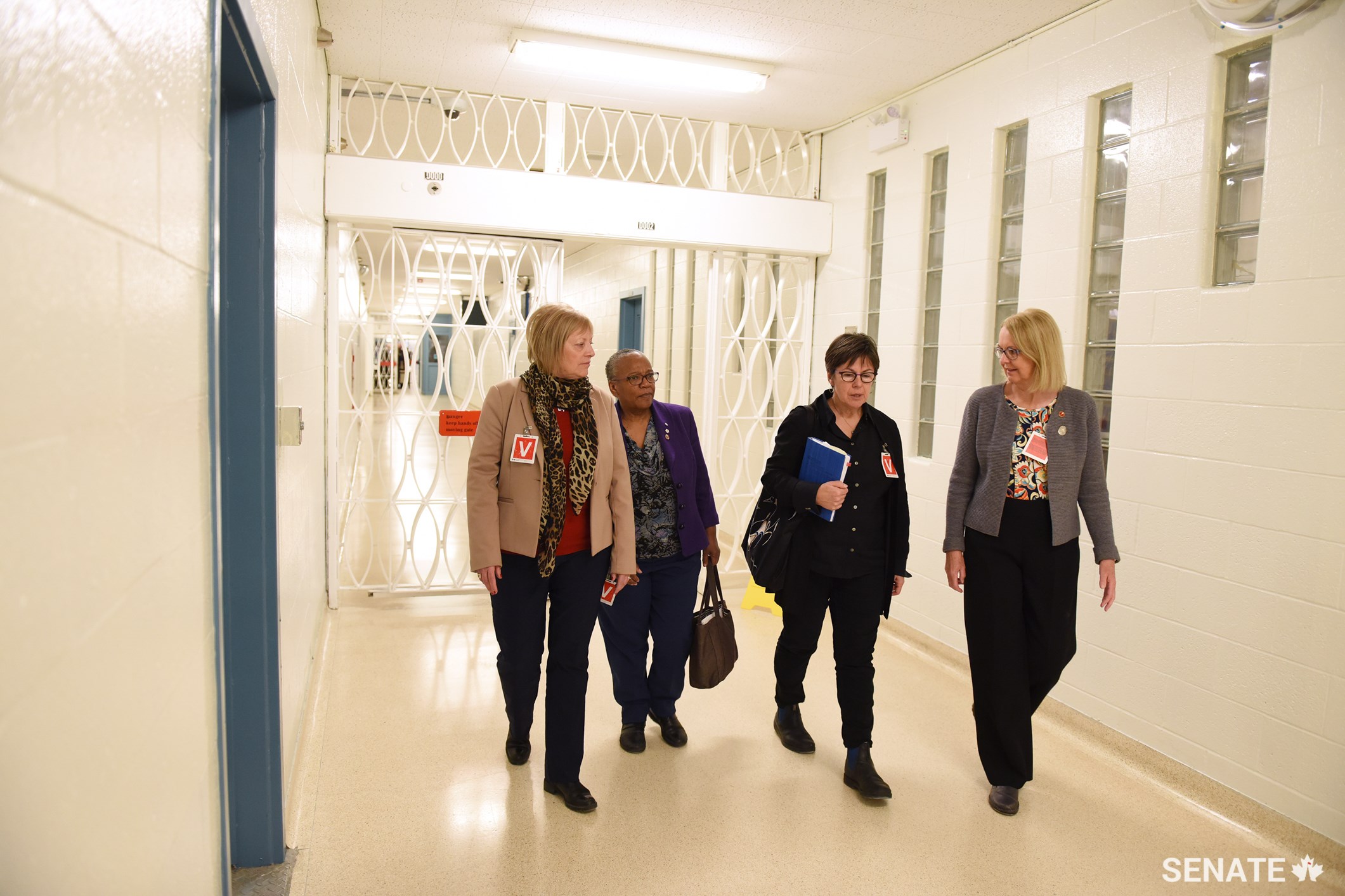 From left, Senators Nancy Hartling, Wanda Thomas Bernard, Kim Pate and Jane Cordy walk through the halls of the Atlantic Institution, a men’s maximum security facility in New Brunswick.