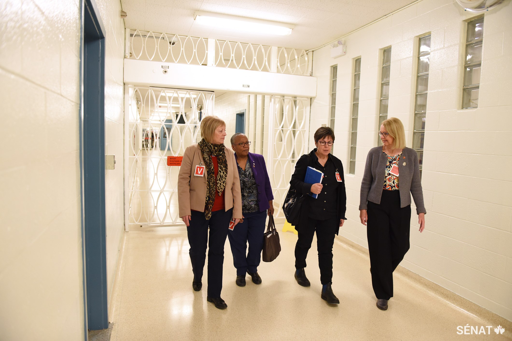 De gauche à droite, les sénatrices Nancy Hartling, Wanda Thomas Bernard, Kim Pate et Jane Cordy marchent dans les corridors de l’Établissement de l’Atlantique, un établissement à sécurité maximale pour hommes au Nouveau Brunswick.