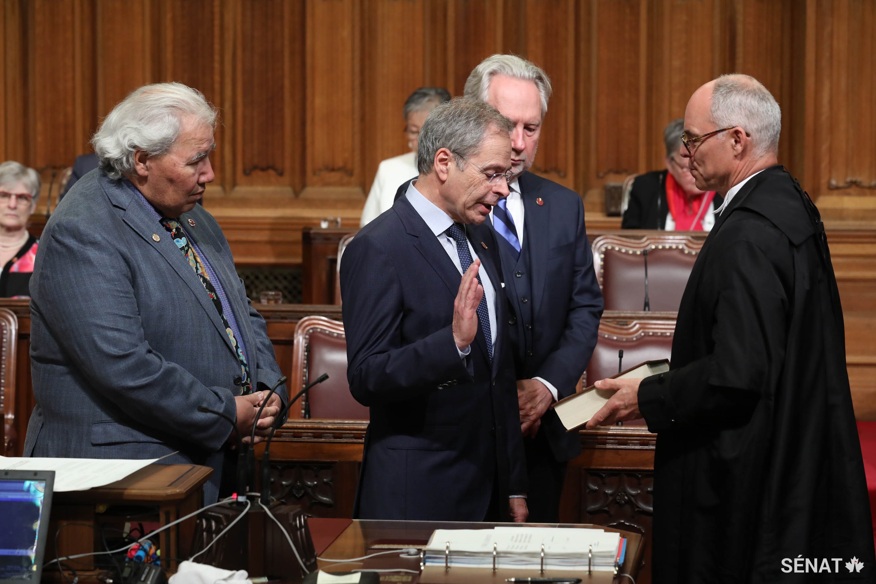 Le sénateur Pierre Dalphond est assermenté par le greffier du Sénat, Richard Denis, le jeudi 7 juin 2018, sous le regard du sénateur Murray Sinclair, à gauche, et du sénateur Peter Harder.