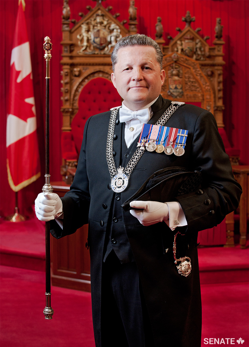 The Usher sports a white bow tie, a bicorne hat and a ceremonial sword in the Senate.