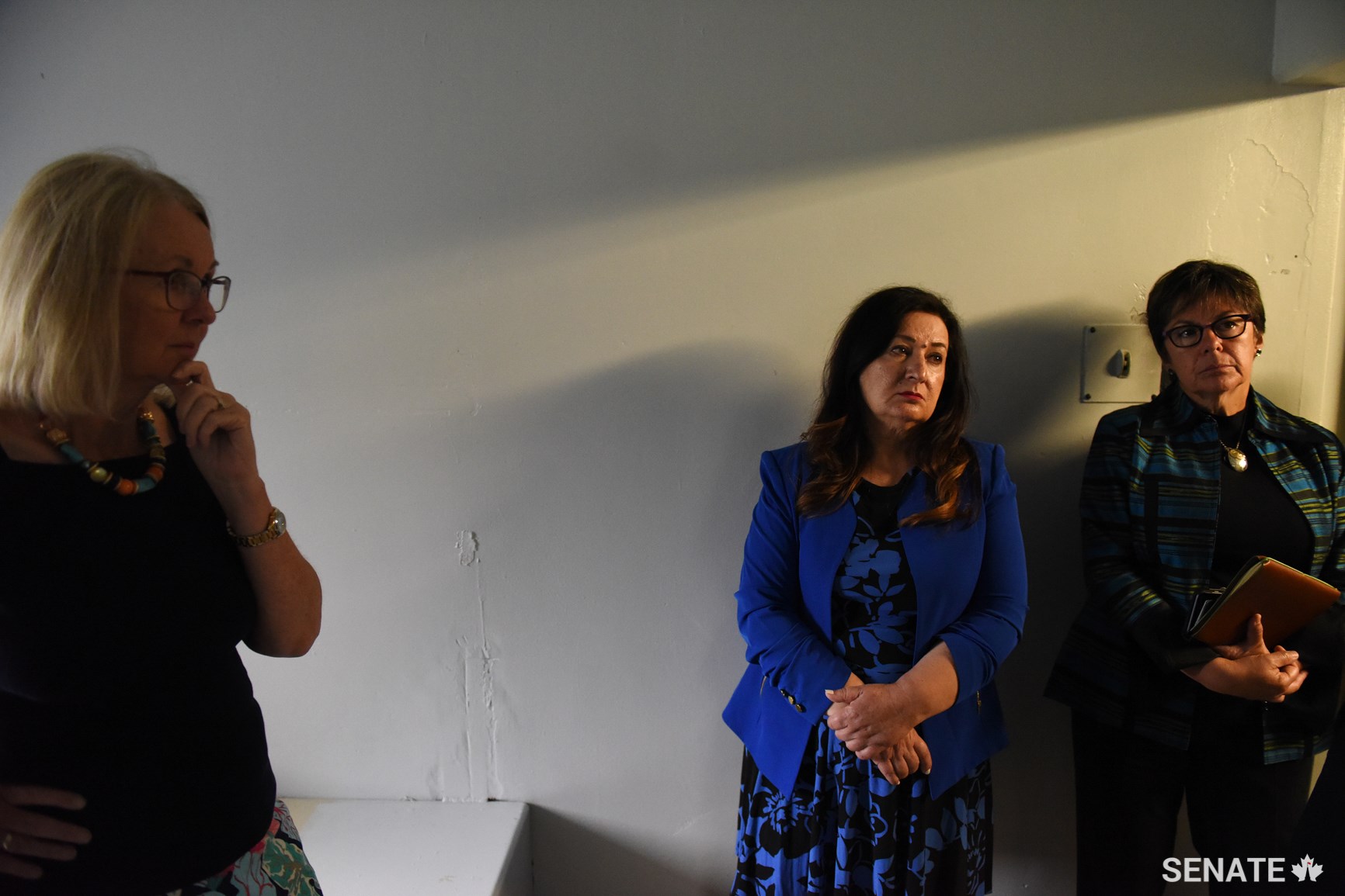 From left, committee deputy chairs senators Jane Cordy and Salma Ataullahjan, and Senator Pate stand in a health unit cell, where prisoners are held before receiving medical attention. Prisoners have often mentioned the lack of health care when speaking to the committee.