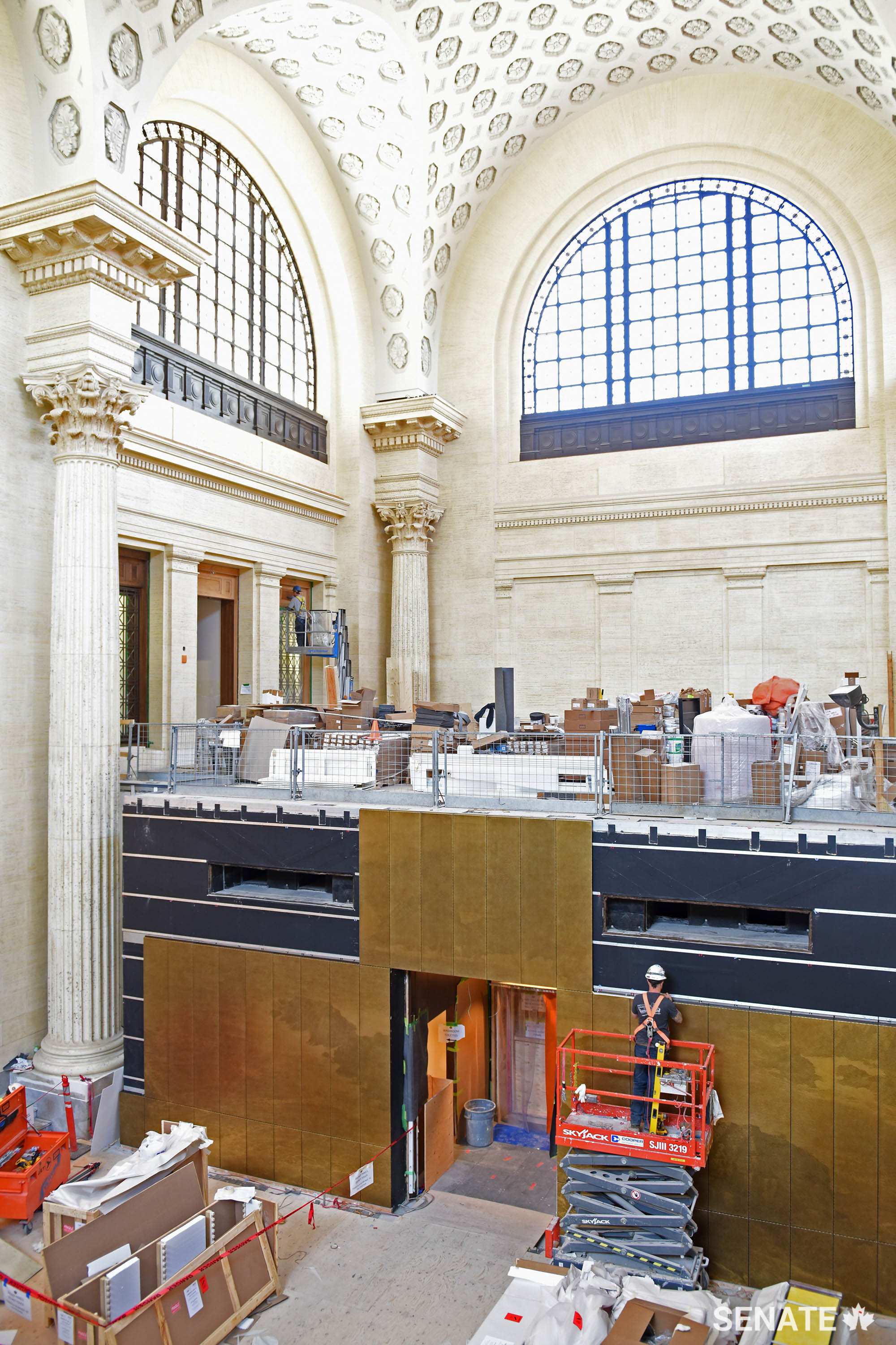 A construction worker installs one of nearly 200 bronze panels that make up three new landscape panoramas in the Government Conference Centre.