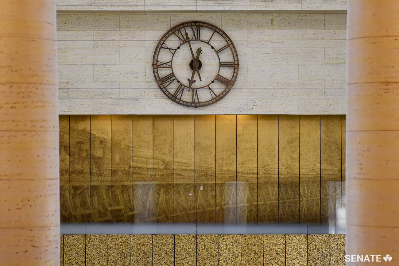 A view of a steam engine pulling a train across a wooden trestle bridge runs along an upper-level gallery.