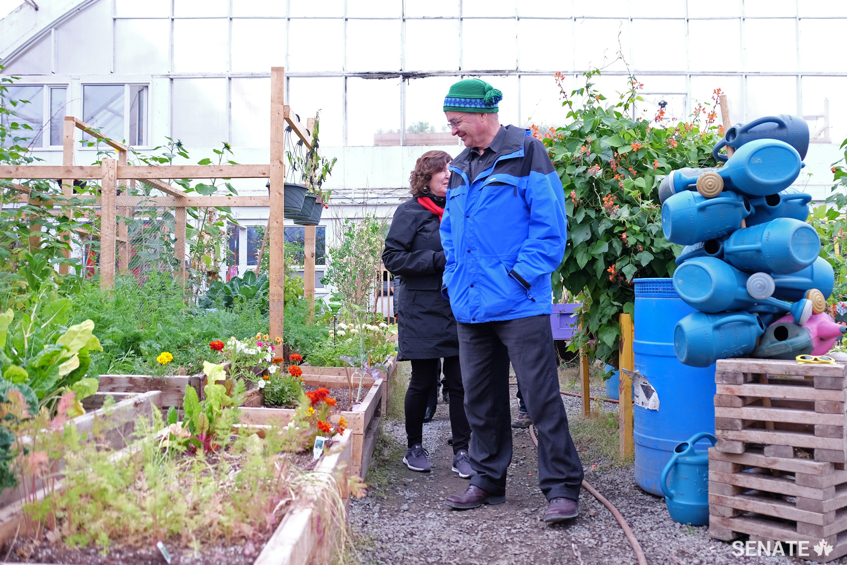 Senators Mary Coyle and Dennis Patterson visit a greenhouse in Inuvik, N.W.T. The facility was formerly an arena for a residential school, which is believed to be the last operational residential school in Canada when it finally closed in 1996. While the school was demolished several years ago, the community has adopted part of the facility as a multi-use space for weddings and other gatherings.