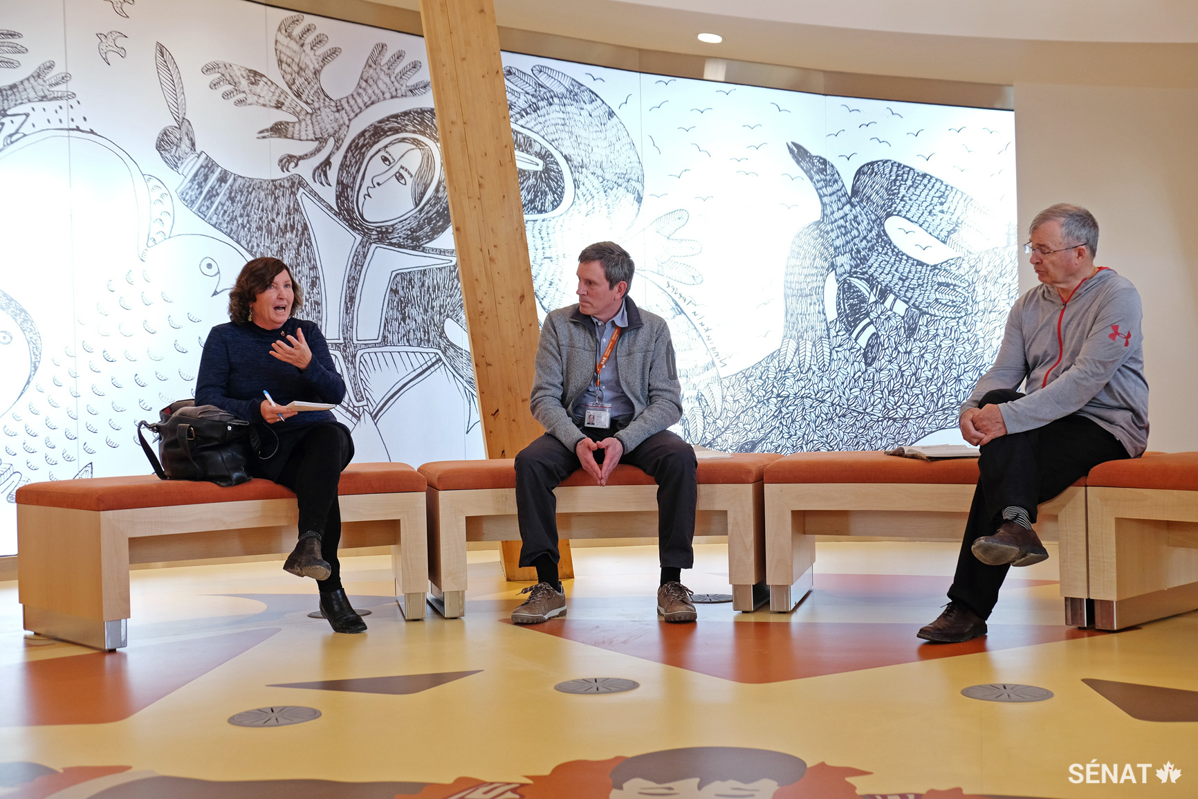 La sénatrice Mary Coyle et le sénateur Dennis Patterson écoutent Alain Leclair, directeur des sciences et technologies de Savoir polaire Canada à la Station canadienne de recherche dans l’Extrême-Arctique de Cambridge Bay, au Nunavut. Cet édifice de 52 000 pieds carrés n’est pas encore officiellement ouvert, mais il servira à la fois d’installation de recherche et de centre communautaire pour les Inuits. En effet, le tiers de l’édifice sera ouvert au grand public, et une partie des locaux sera réservée au partage du savoir autochtone sur l’Arctique et à l’enregistrement des traditions orales des aînés inuits.