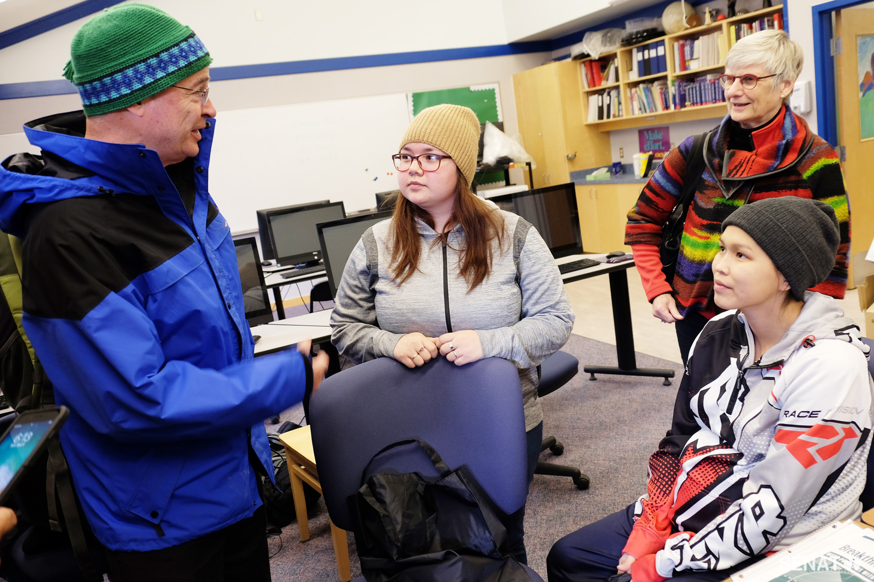 Le sénateur Dennis Patterson, président du Comité spécial sur l’Arctique, et la sénatrice Patricia Bovey, vice-présidente, rencontrent de jeunes Inuits à Cambridge Bay, au Nunavut. Leanne Beaulieu, 22 ans, à gauche, et Kayla Carter, 26 ans, à droite, étudient toutes deux au Collège de l’Arctique. Elles ont dit aux sénateurs que l’accès à Internet est gratuit au collège, mais que chez elles, leur famille paie 84 $ par mois pour à peine 25 Go de données, transmissibles lentement par satellite. Grâce à la nouvelle Station canadienne de recherche dans l’Extrême-Arctique, à Cambridge Bay, les étudiants pourront recevoir en classe des chercheurs locaux et accéder à de l’équipement et à des laboratoires.