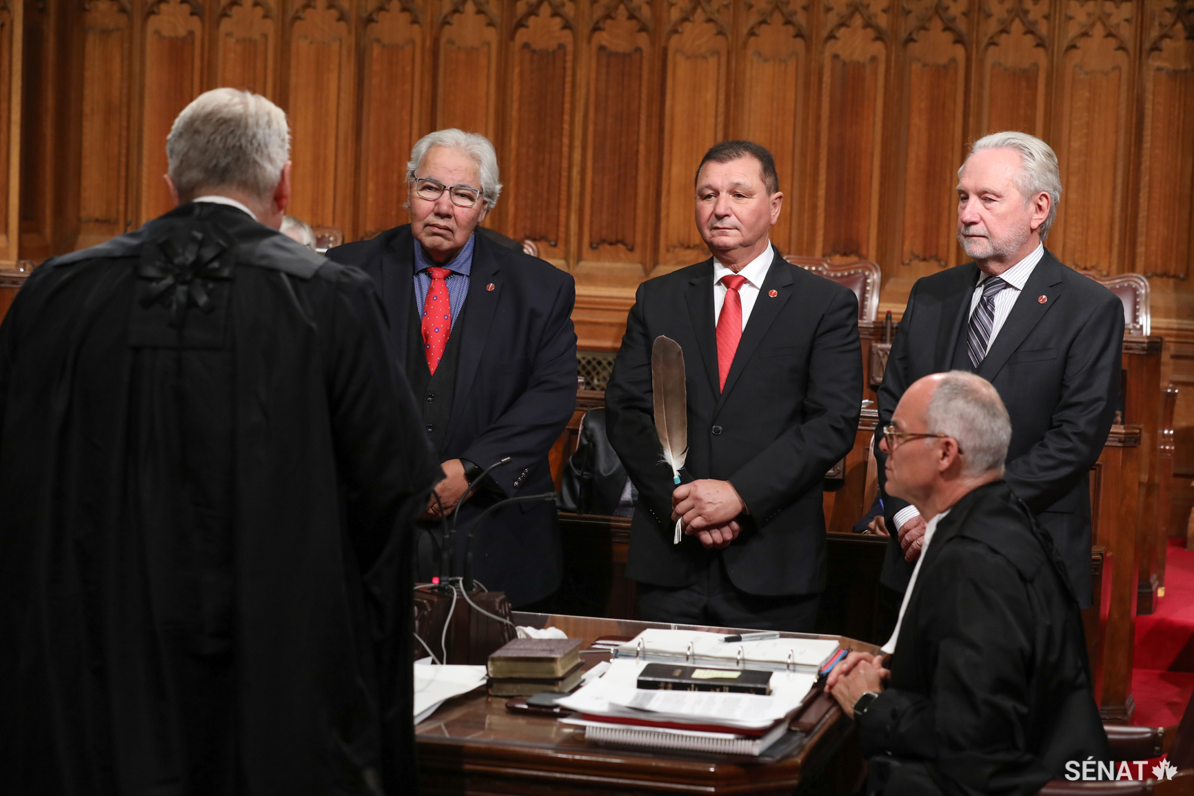 Le sénateur Brian Francis, au centre, est accompagné des sénateurs Murray Sinclair et Peter Harder lors de sa cérémonie d’assermentation.