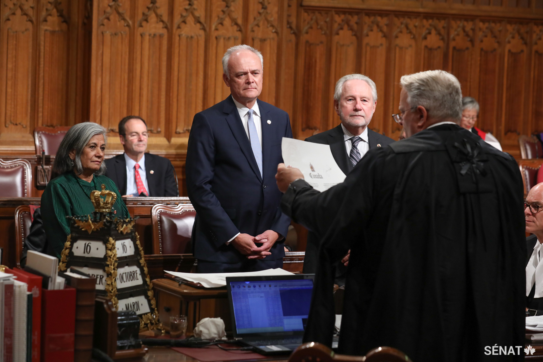Blair Armitage, greffier principal du Sénat, lit le serment lors de la cérémonie d’assermentation du sénateur Peter M. Boehm, au centre, le 16 octobre 2018.