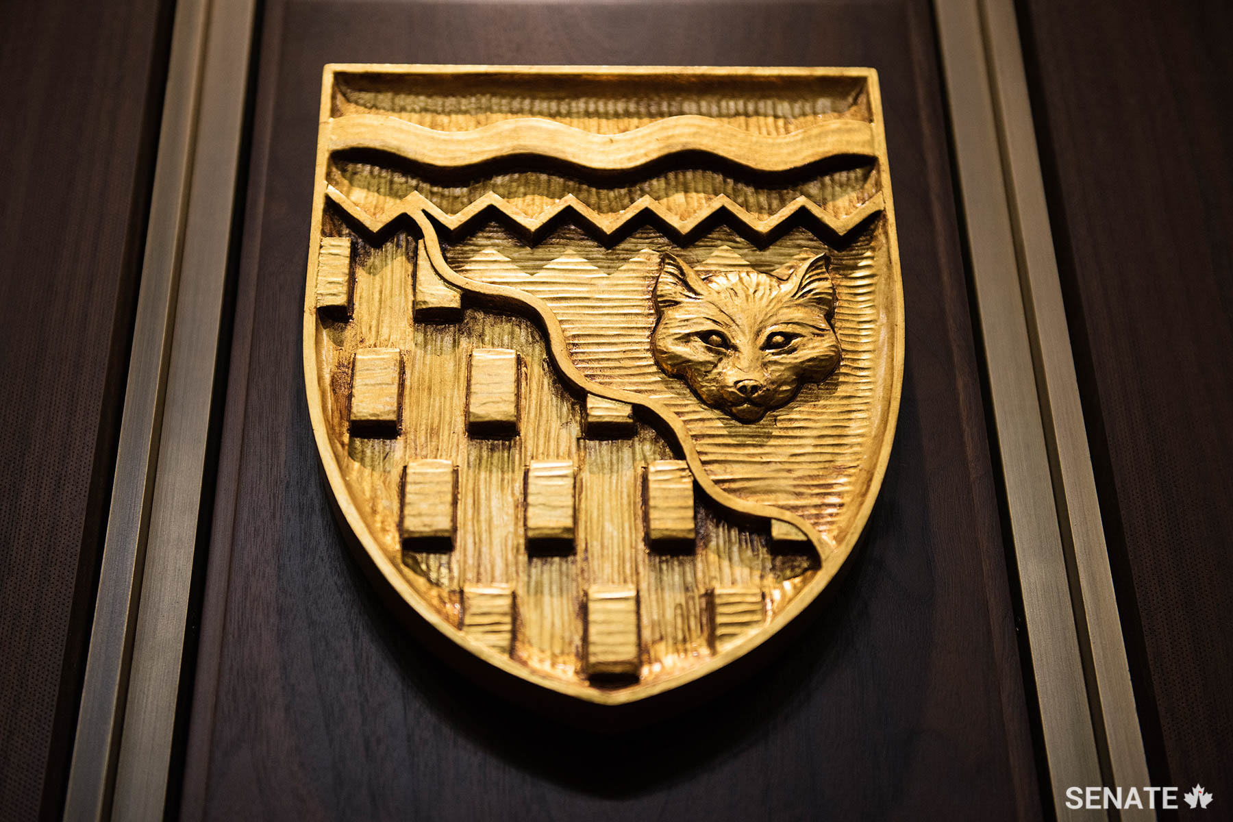 The shield of the Northwest Territories features a wavy diagonal line representing the tree line, a horizontal one representing the Northwest Passage and a white fox and gold bars symbolizing the North’s fur and mineral wealth respectively.
