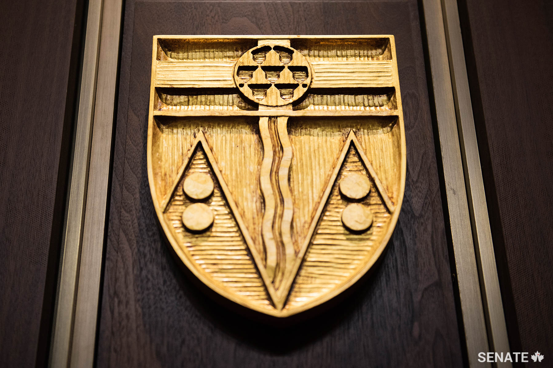 The lower part of Yukon’s shield represents the territory’s mountains. Gold disks evoke its mineral wealth and its founding during the Klondike Gold Rush. The medallion at the top contains a heraldic pattern called a vair that represents the fur trade’s importance to the territory’s economy.