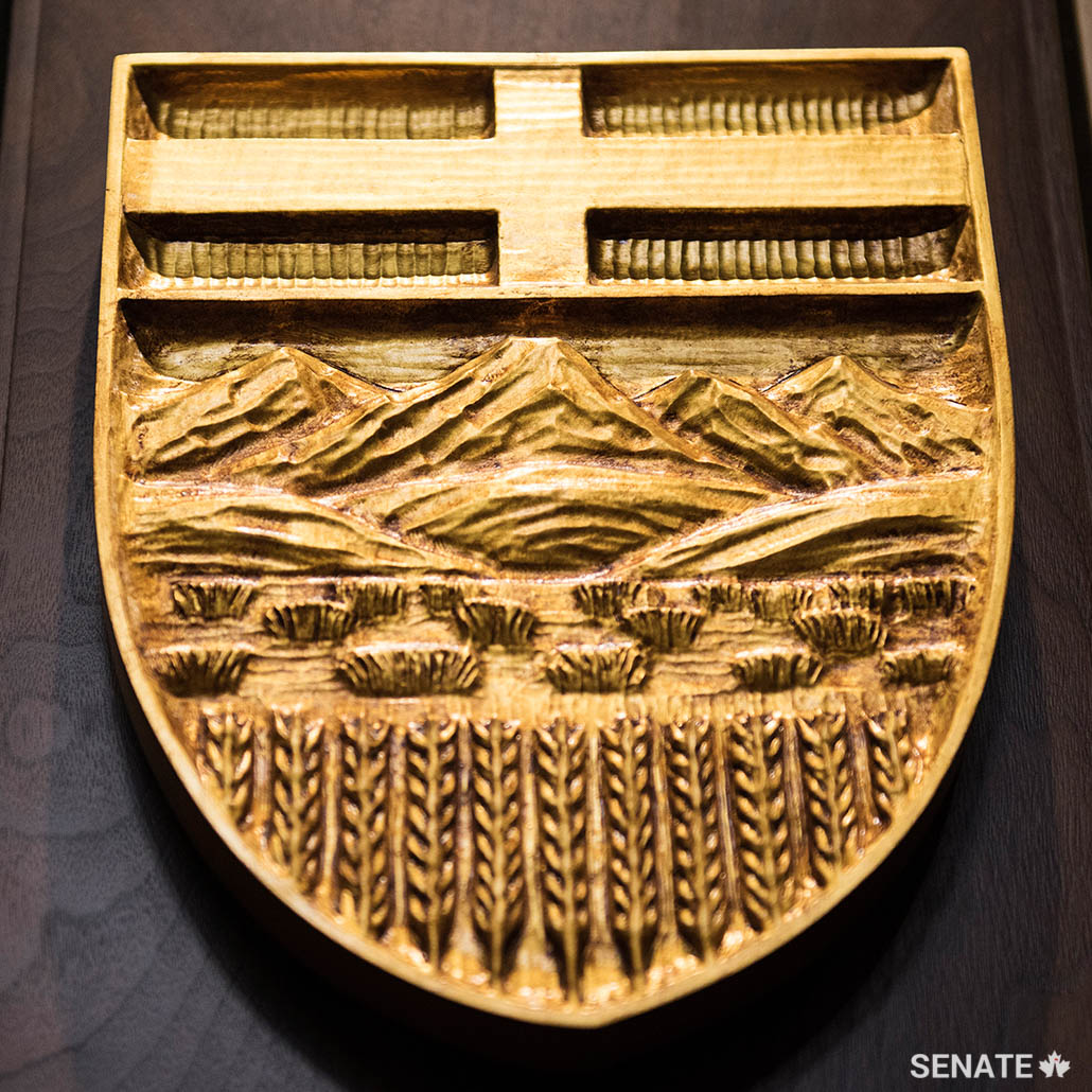 The Rocky Mountains form a backdrop to wheat fields on the Alberta provincial shield.