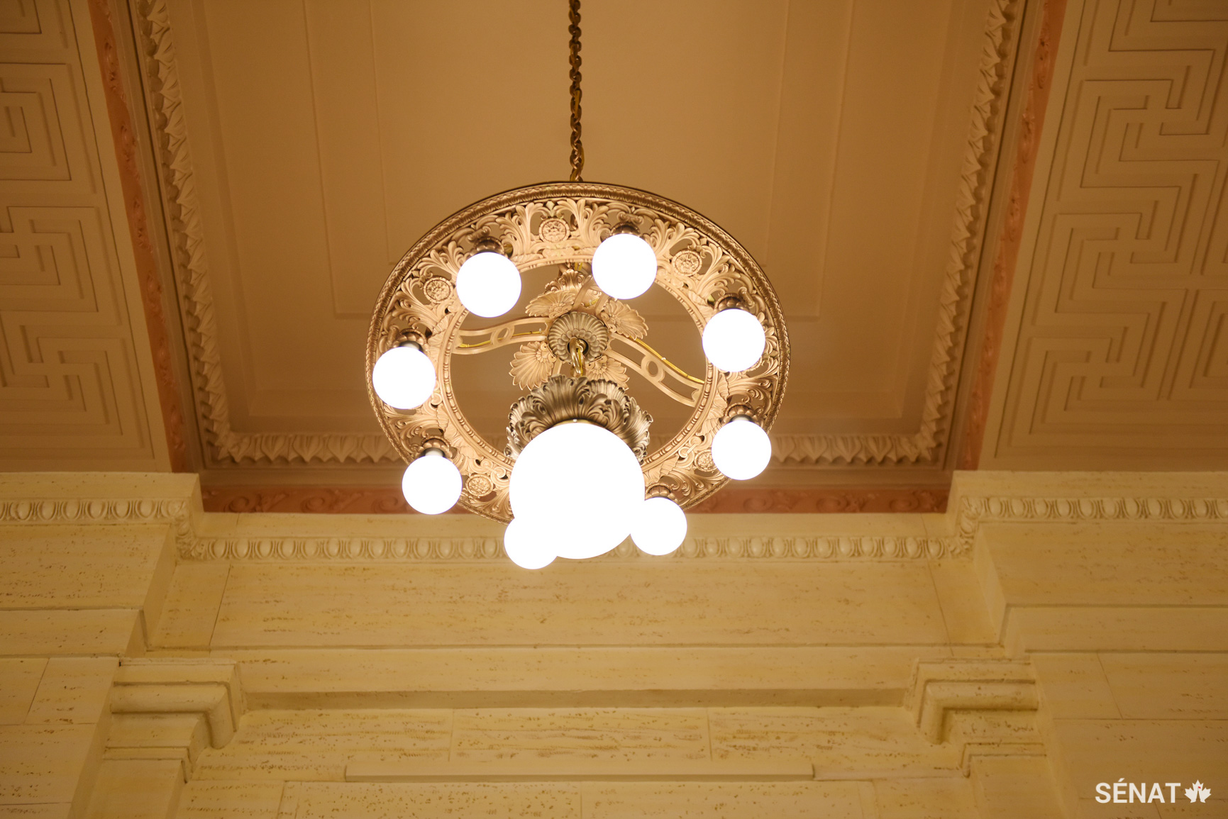 Les lustres originaux de 1912 de l’édifice ont été soigneusement retirés, nettoyés et restaurés avec un nouvel éclairage à DEL et de nouvelles composantes électriques afin d’améliorer leur efficacité énergétique. Les récentes avancées de la technologie DEL permettent aux architectes de conserver la lumière chaude des luminaires d’origine.