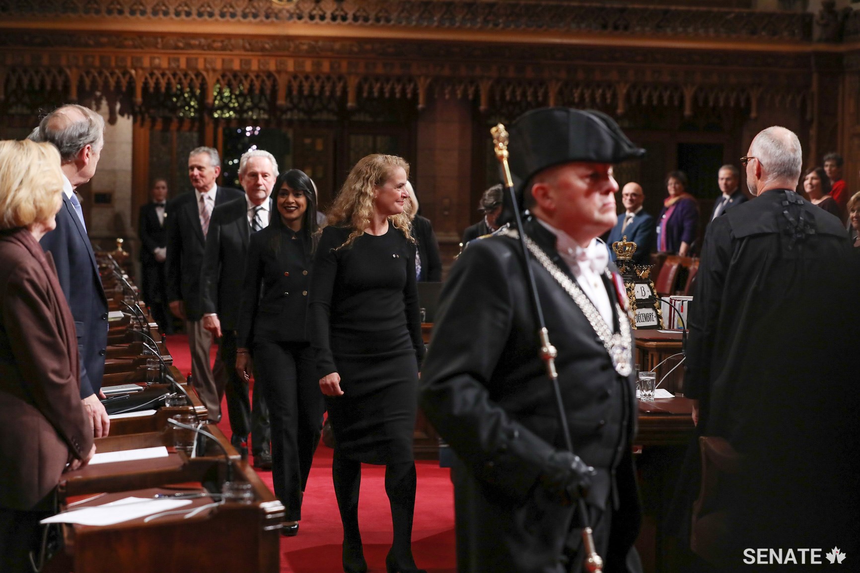 Governor General Julie Payette is escorted into the Senate Chamber by the Usher of the Black Rod to grant Royal Assent to six bills. Behind her are Leader of the Government in the House of Commons Bardish Chagger, Government Representative in the Senate Senator Peter Harder and Leader of the Opposition Senator Larry Smith.