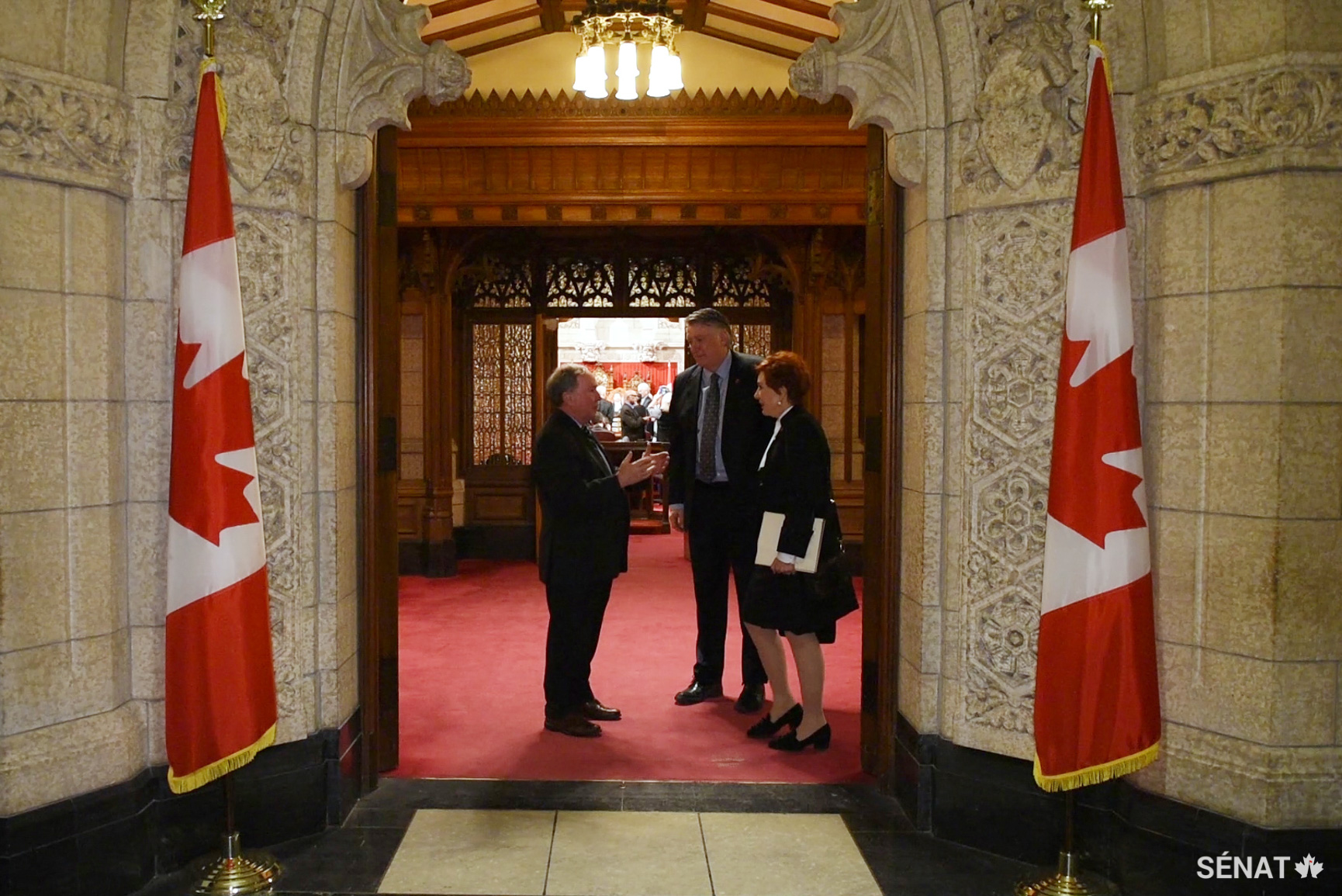 Les sénateurs Jim Munson, Scott Tannas et Nicole Eaton discutent dans l’antichambre alors qu’ils sortent de la Chambre du Sénat de l’édifice du Centre pour la dernière fois avant le début des importants travaux de restauration.