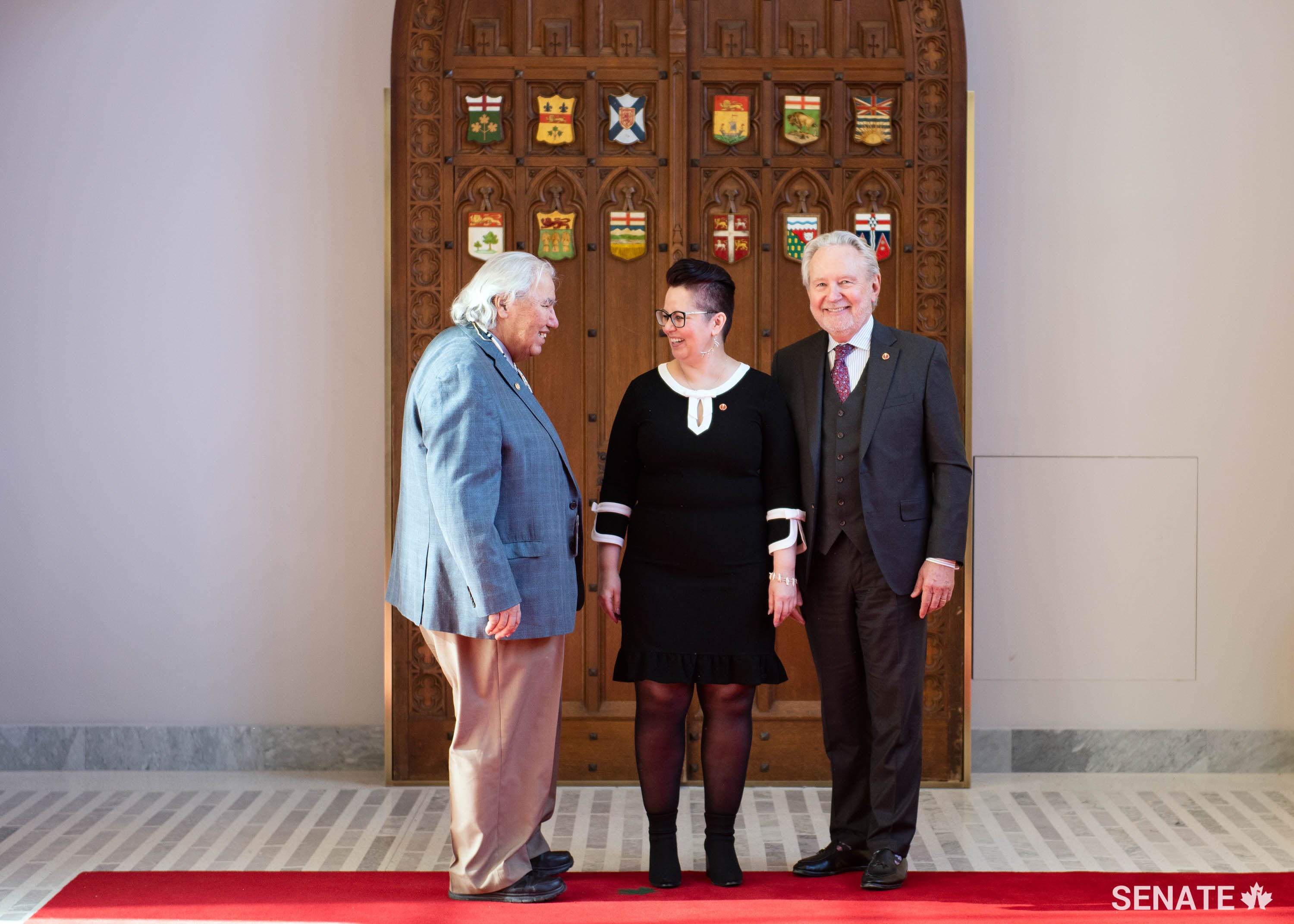 Senator Murray Sinclair, left, and Senator Peter Harder welcome Senator Margaret Dawn Anderson to the Senate after her swearing-in ceremony on February 19, 2019.