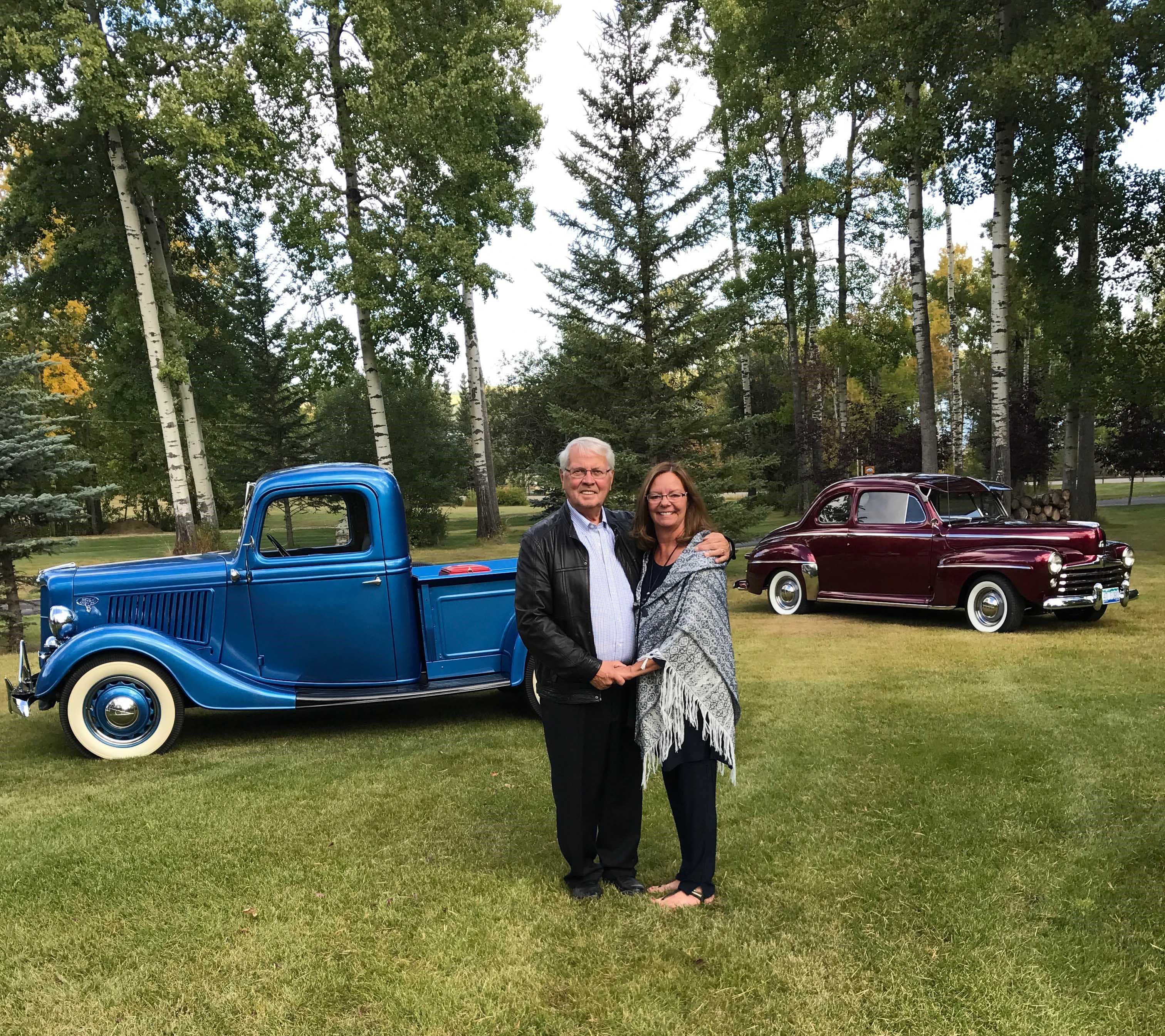 Senator Richard Neufeld and his wife, Montana Currie, with two of their vintage cars. Together, they have collected four vintage cars and few motorcycles.