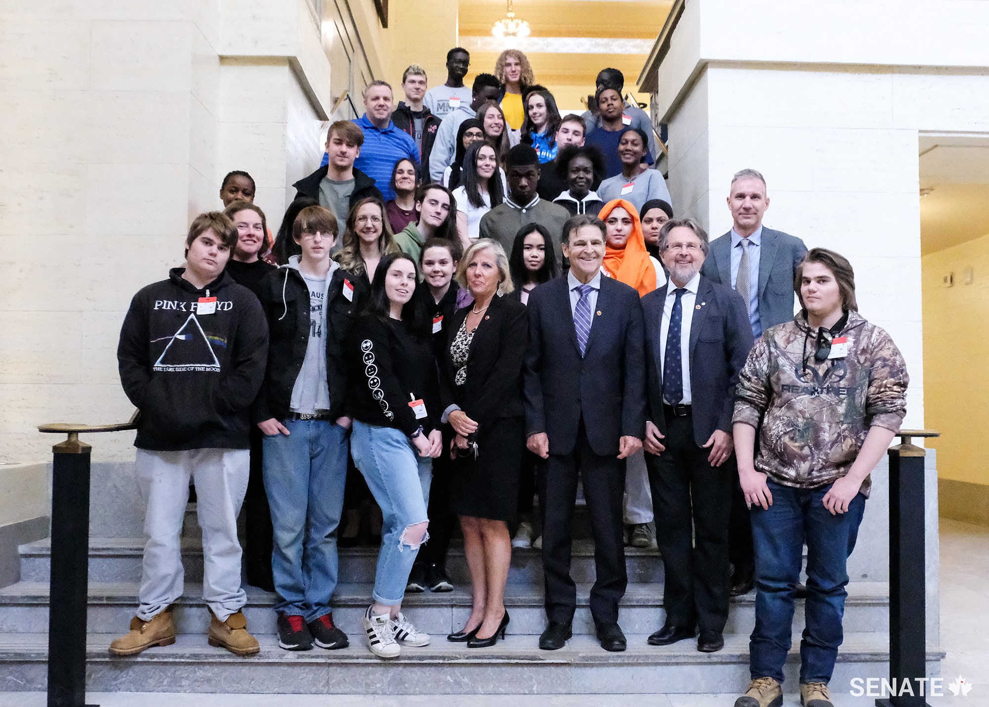 Senators Marty Deacon, Paul E. McIntyre and Stan Kutcher meet with students in the foyer of the Senate of Canada Building after participating in the workshop.