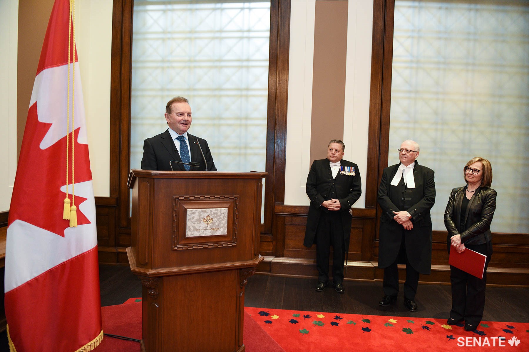 Senator Joyal delivers remarks during an event celebrating the book launch at the Senate of Canada building on May 14, 2019. Listening, from right, are Senator Seidman, Speaker of the Senate George J. Furey and Usher of the Black Rod J. Greg Peters.