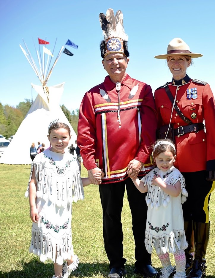 Senator Brian Francis stands with granddaughters Kate and Kiara, and a former Commanding Officer from the Royal Canadian Mounted Police in Prince Edward Island.
