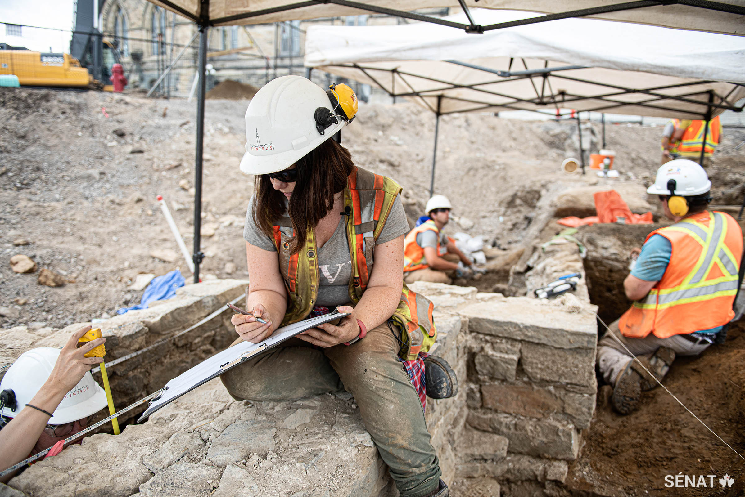 L’archéologue Becky Remmer réalise un dessin à l’échelle du mur de fondation du poste de garde.