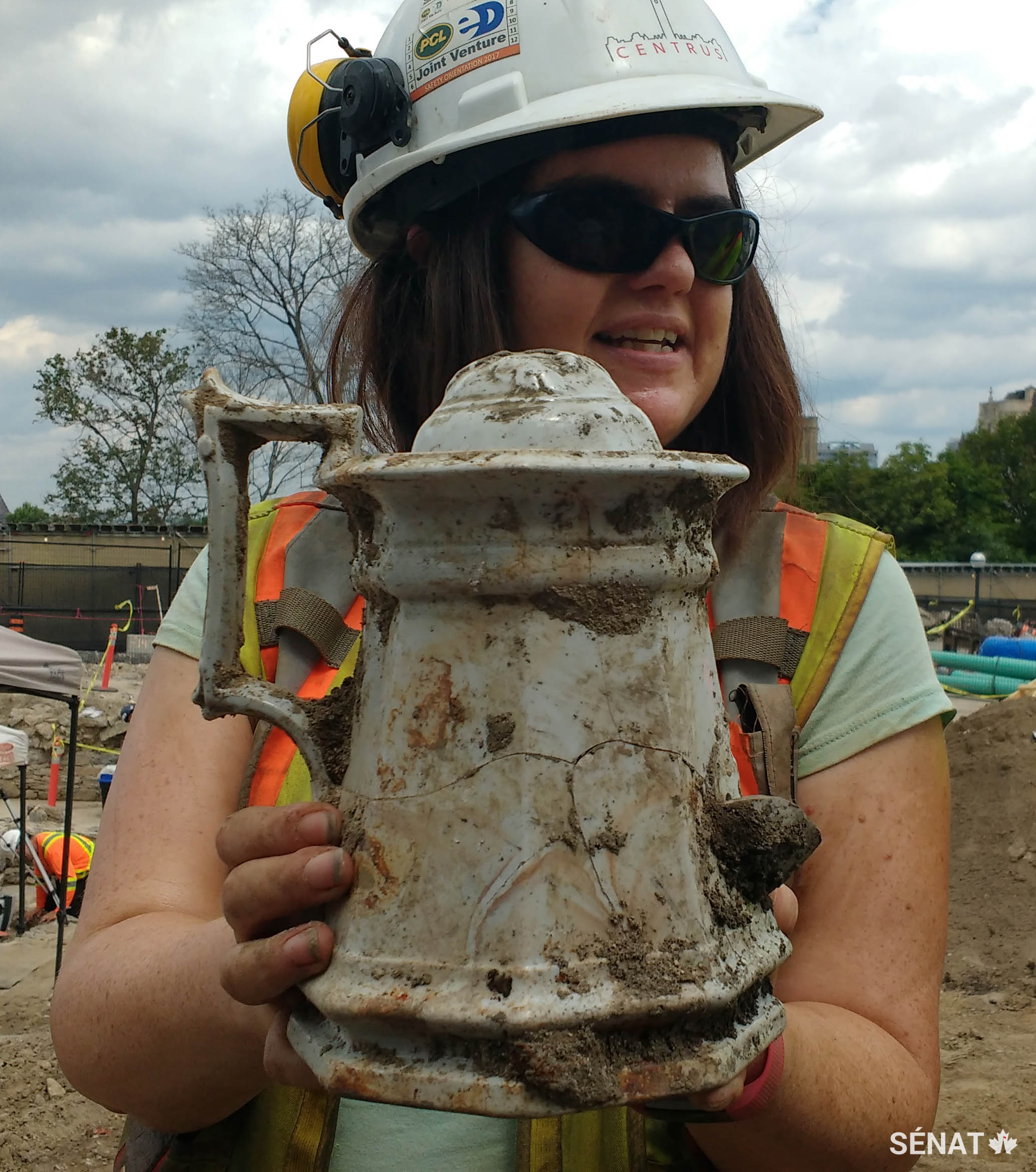 L’archéologue Becky Remmer tient une théière découverte sur le site.