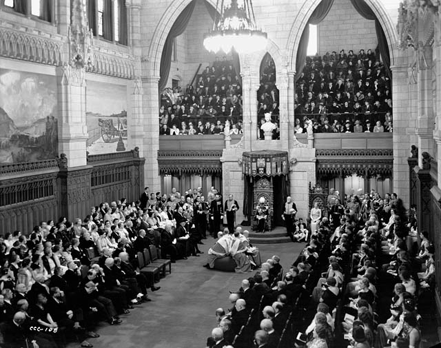 Governor General Lord Tweedsmuir reads the Speech from the Throne during the opening of the third session of Canada’s 18th Parliament in 1938. Directly in front of him, Canada’s Supreme Court judges sit on the woolsack. (Library and Archives Canada)