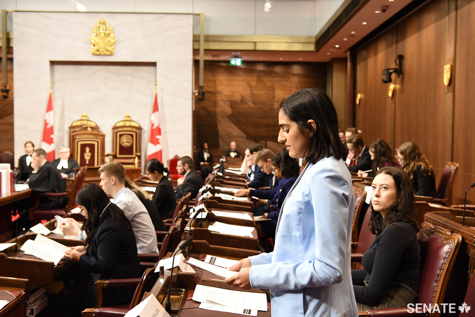 A model senator organizes her notes as she gives a speech in the Senate Chamber.