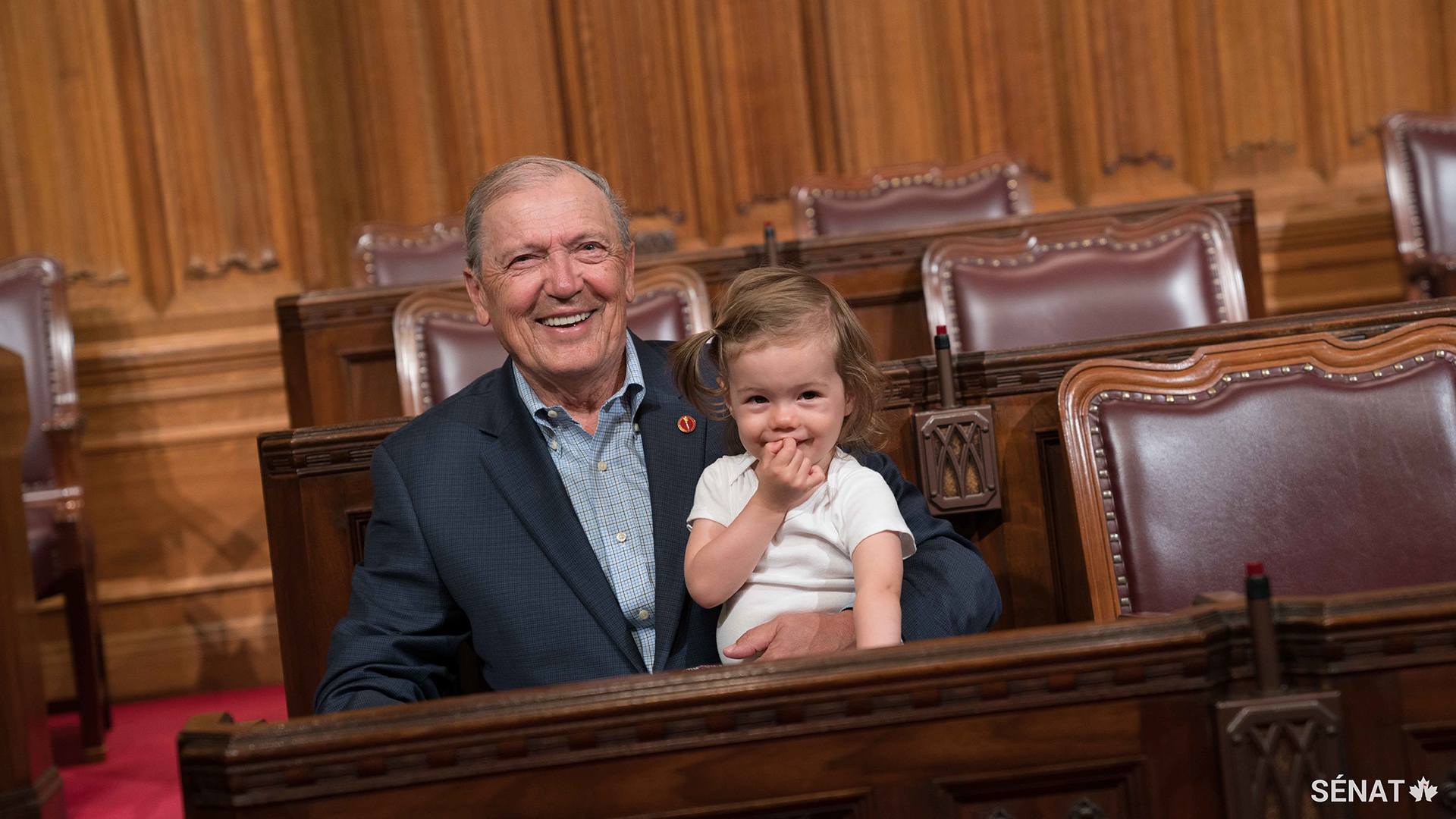Le sénateur Tkachuk et sa petite-fille échangent un sourire et un câlin dans la Chambre du Sénat en 2017. Il se réjouit à l’idée de passer plus de temps avec sa famille pendant sa retraite.