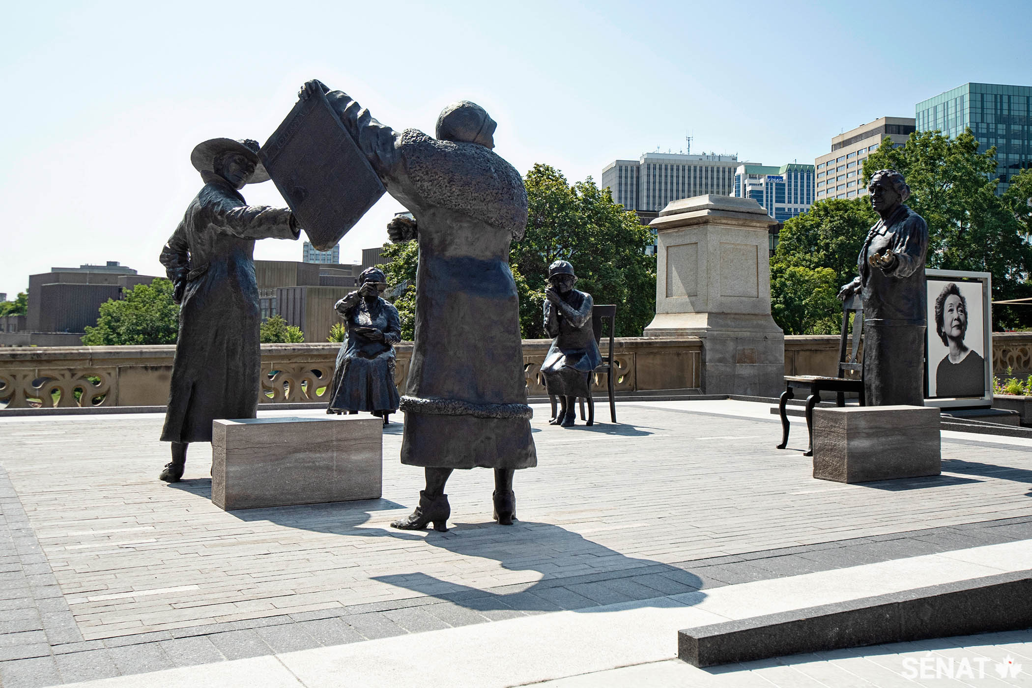 Nellie McClung brandit un journal proclamant « Les femmes sont des personnes! », tandis que les autres portent un toast à la décision du Conseil privé.