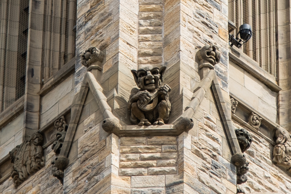 A grotesque musician squats high on the Peace Tower, part of an ensemble that alludes to the carillon inside and the structure’s role as a bell tower. (Photo credit: House of Commons)
